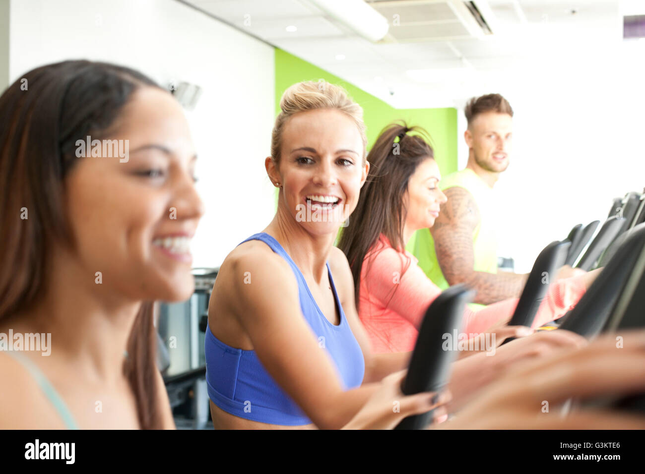 Femme dans une salle de sport à l'aide de machine d'exercice smiling Banque D'Images