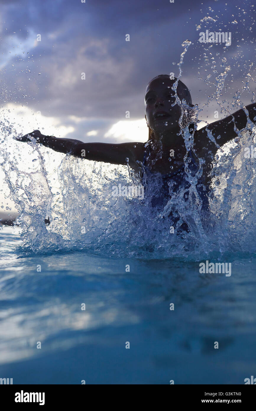 Silhouetté girl splashing in swimming pool, Castelnuovo Berardenga, Toscane, Italie Banque D'Images