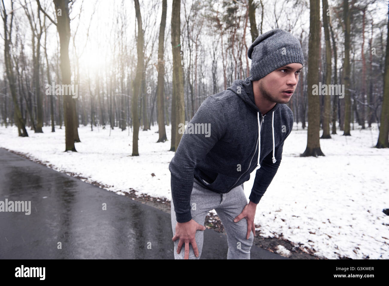 Young man exercising in snowy forest Banque D'Images