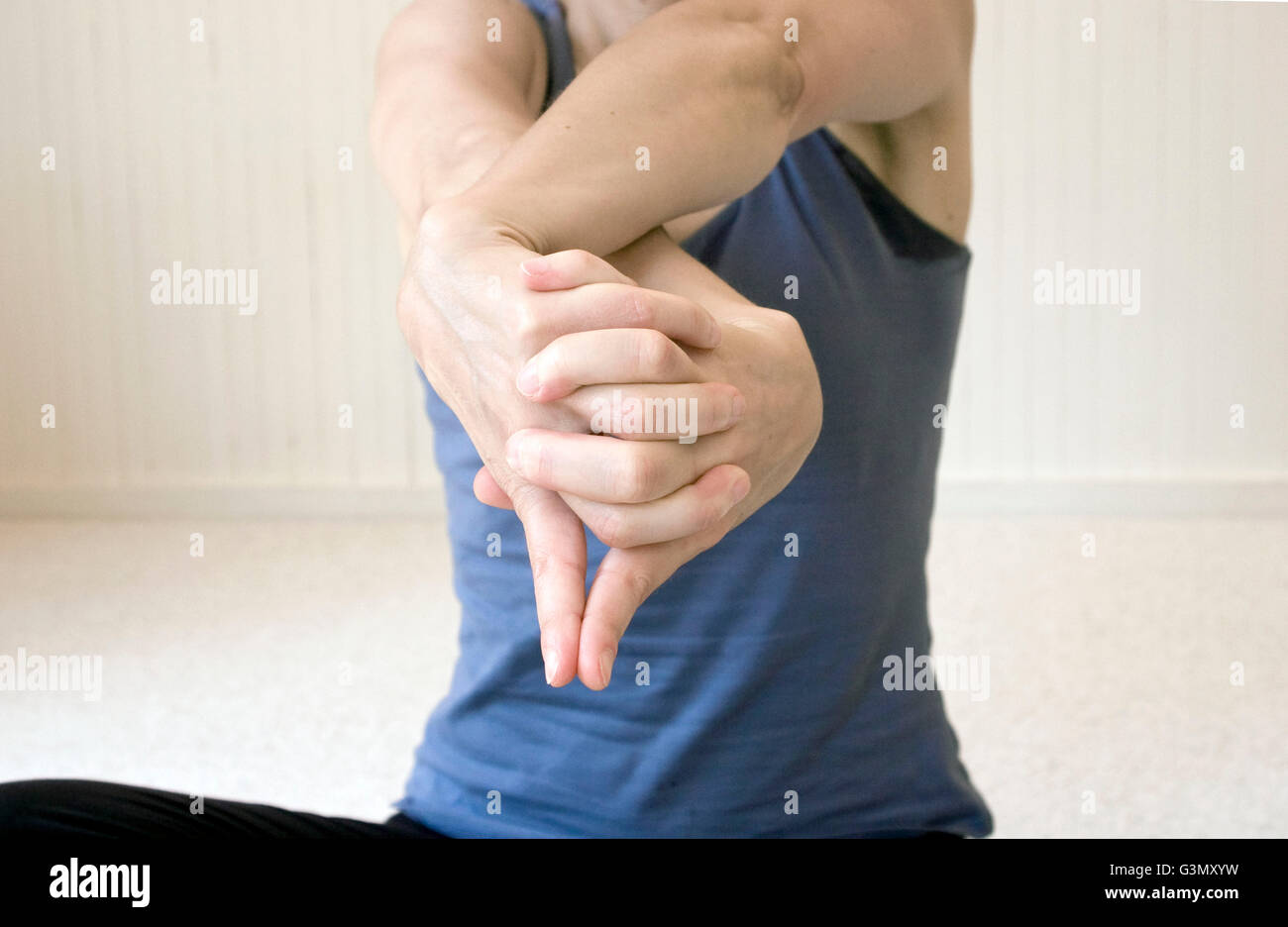 Femme pratiquant de yoga l'exécution d'une position de la main (mudra) dans le studio Banque D'Images