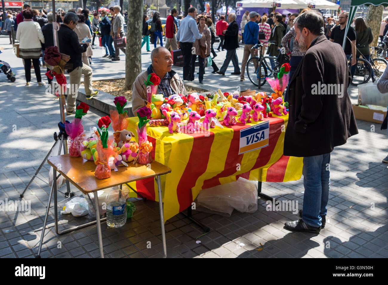 Stand du marché avec la vente de drapeaux catalans dragons en peluche sur Diada de Sant Jordi (Saint George's Day), le 23 avril, Barcelone. Banque D'Images