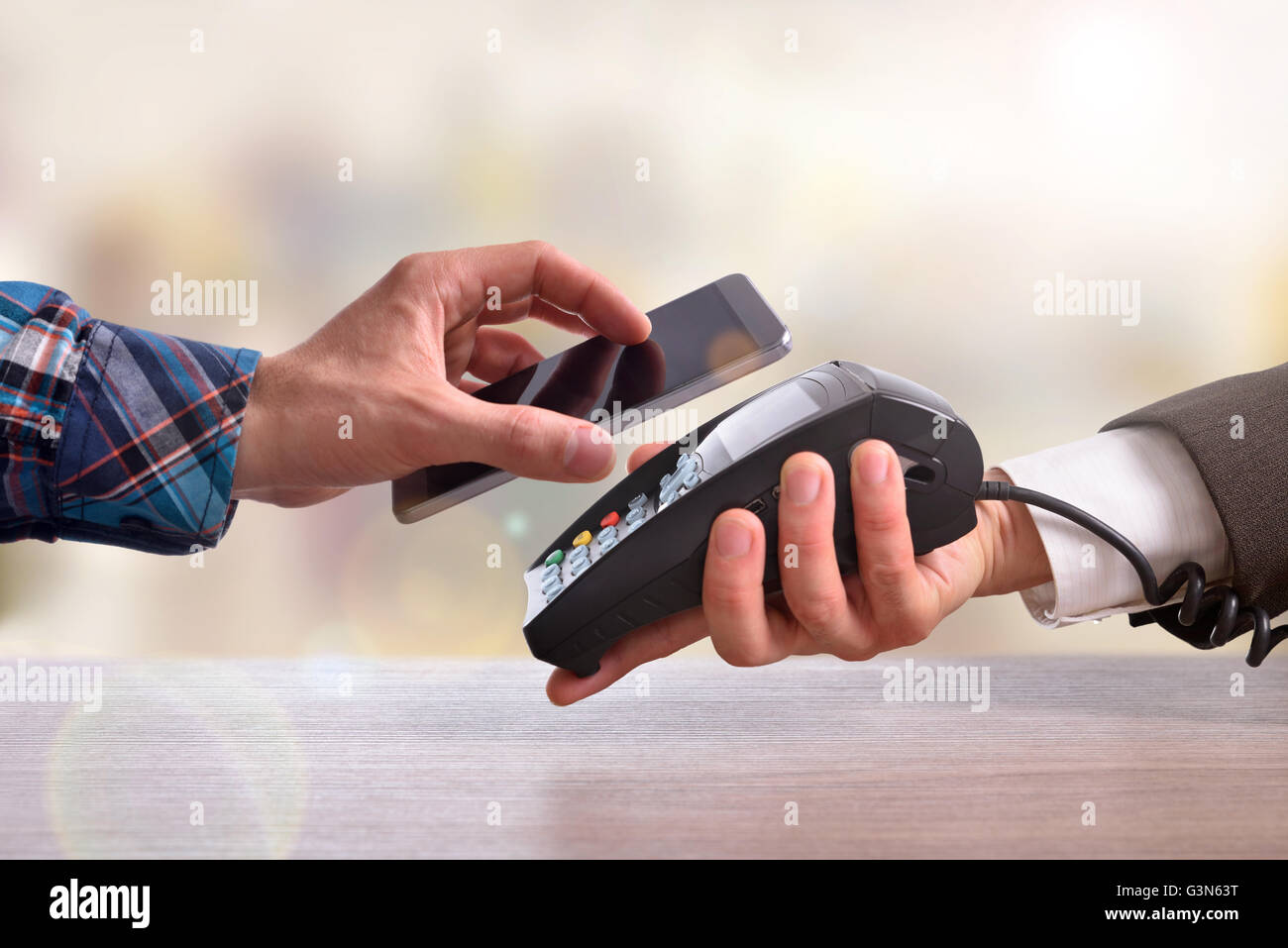 Le client paie un marchand avec téléphone mobile avec la technologie NFC. Vue d'en haut. Composition horizontale. Banque D'Images