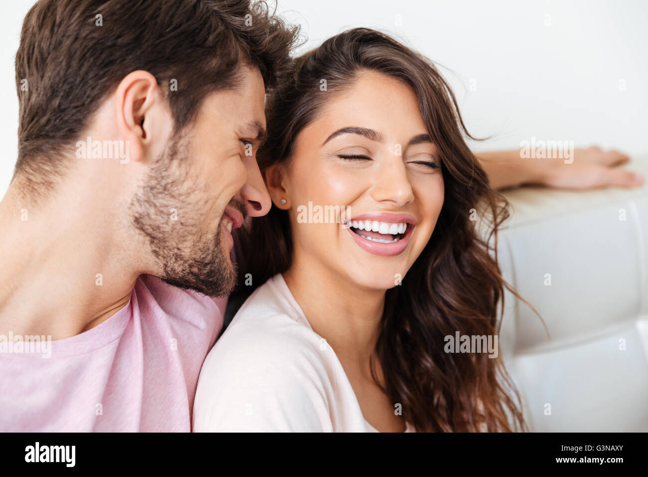 Close-up portrait of smiling young couple sitting on the couch isolé sur fond blanc Banque D'Images