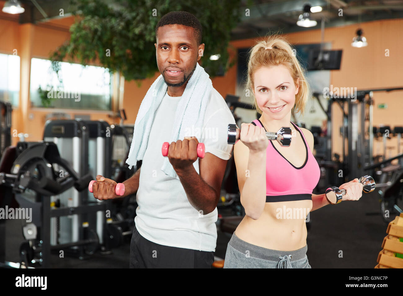 Couple Interracial la formation avec des poids à la salle de sport Banque D'Images
