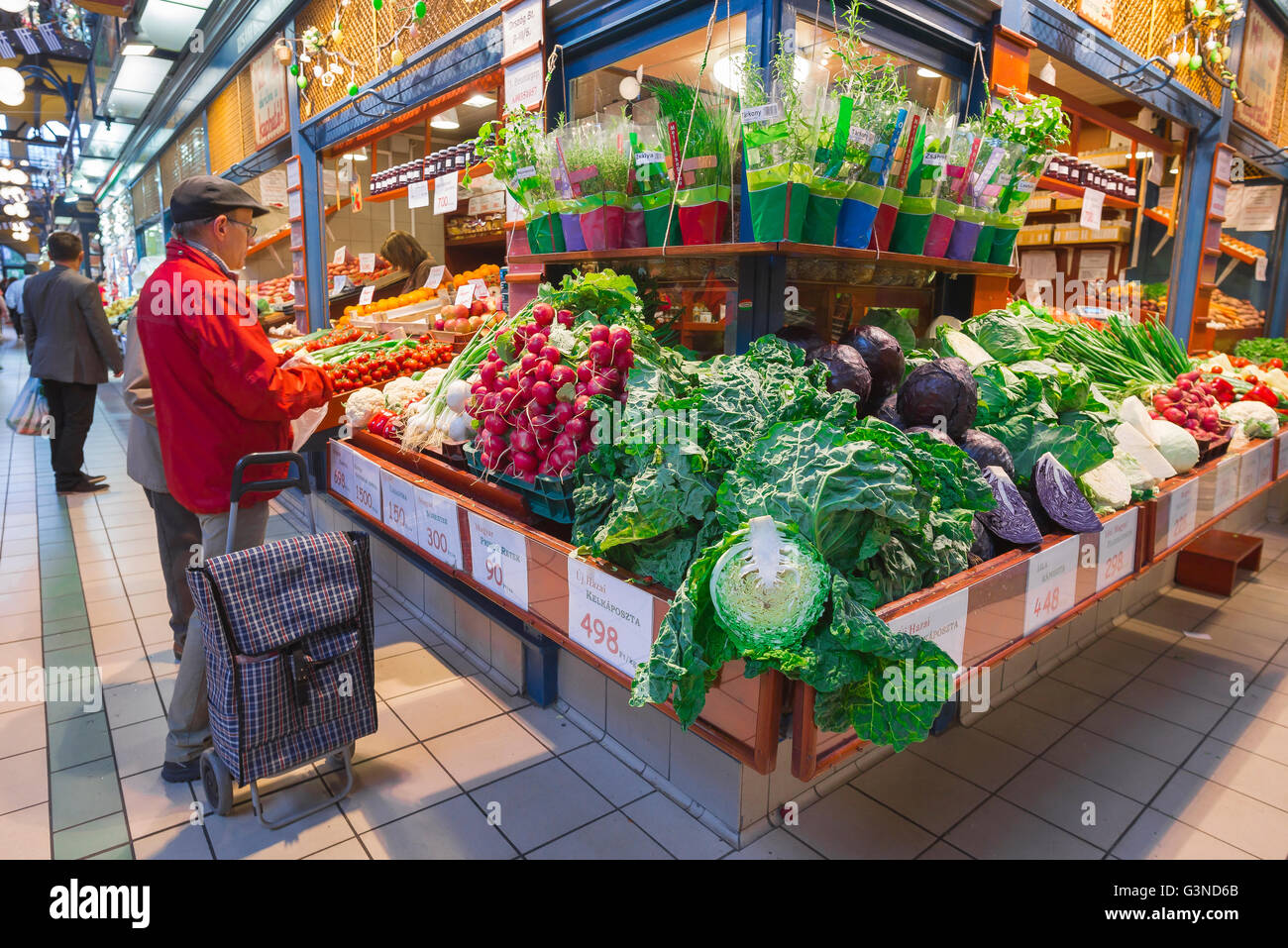 Marché alimentaire de Budapest, un homme achète des légumes à l'intérieur de la Grande Halle dans la région de Jozsefvaros de Budapest, Hongrie. Banque D'Images