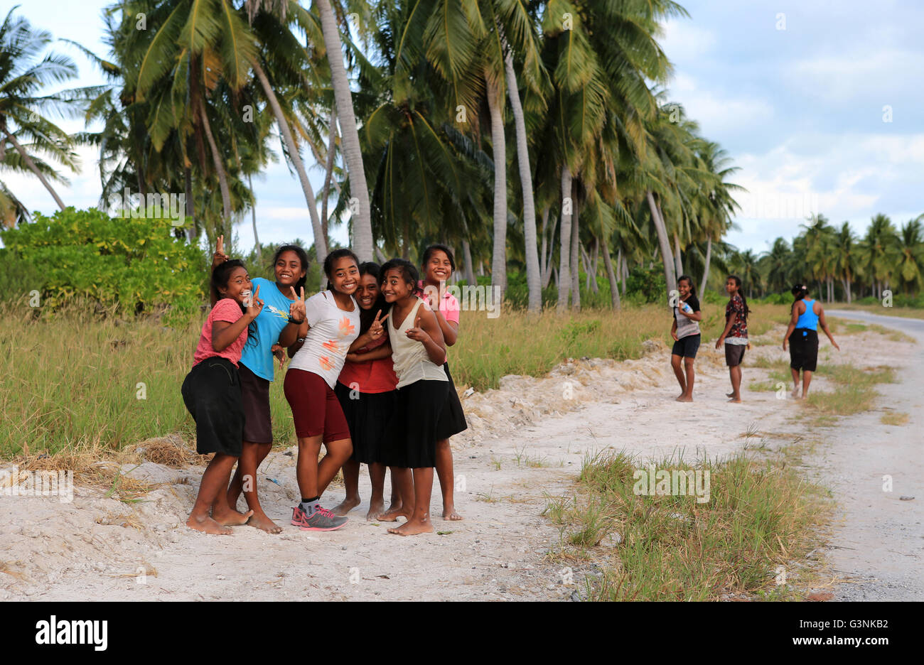 Jeunes filles marchant le long de la route dans la soirée, l'île Christmas, Kiribati Banque D'Images