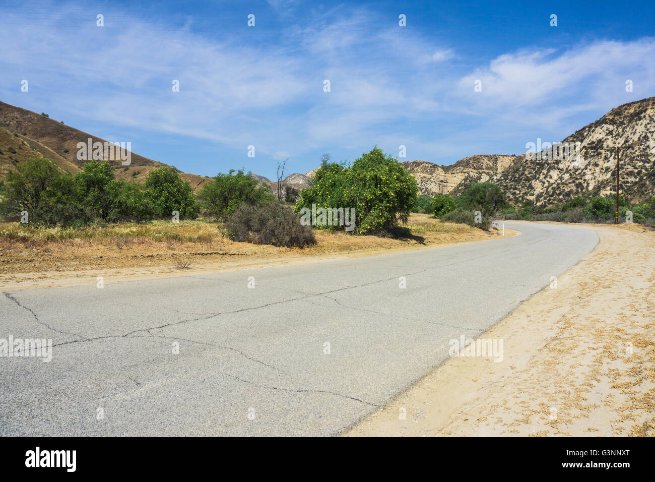 Ancienne route en Californie hills se plie autour d'un coin aigu et roule dans la distance. Banque D'Images