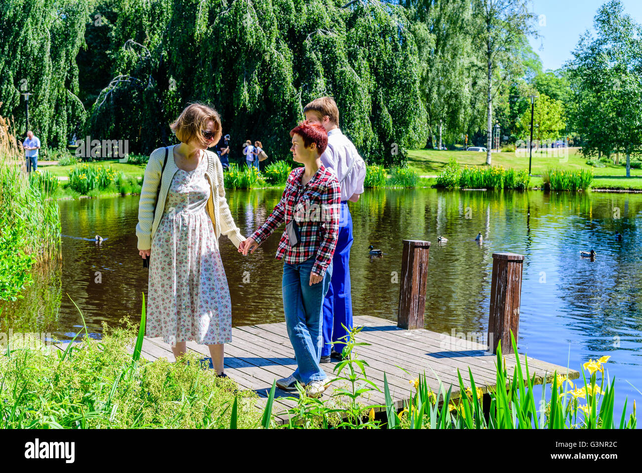 Ronneby, Suède - 6 juin 2016 : la fête nationale suédoise en parc public. Mère, fille et fils sur une jetée en bois w Banque D'Images