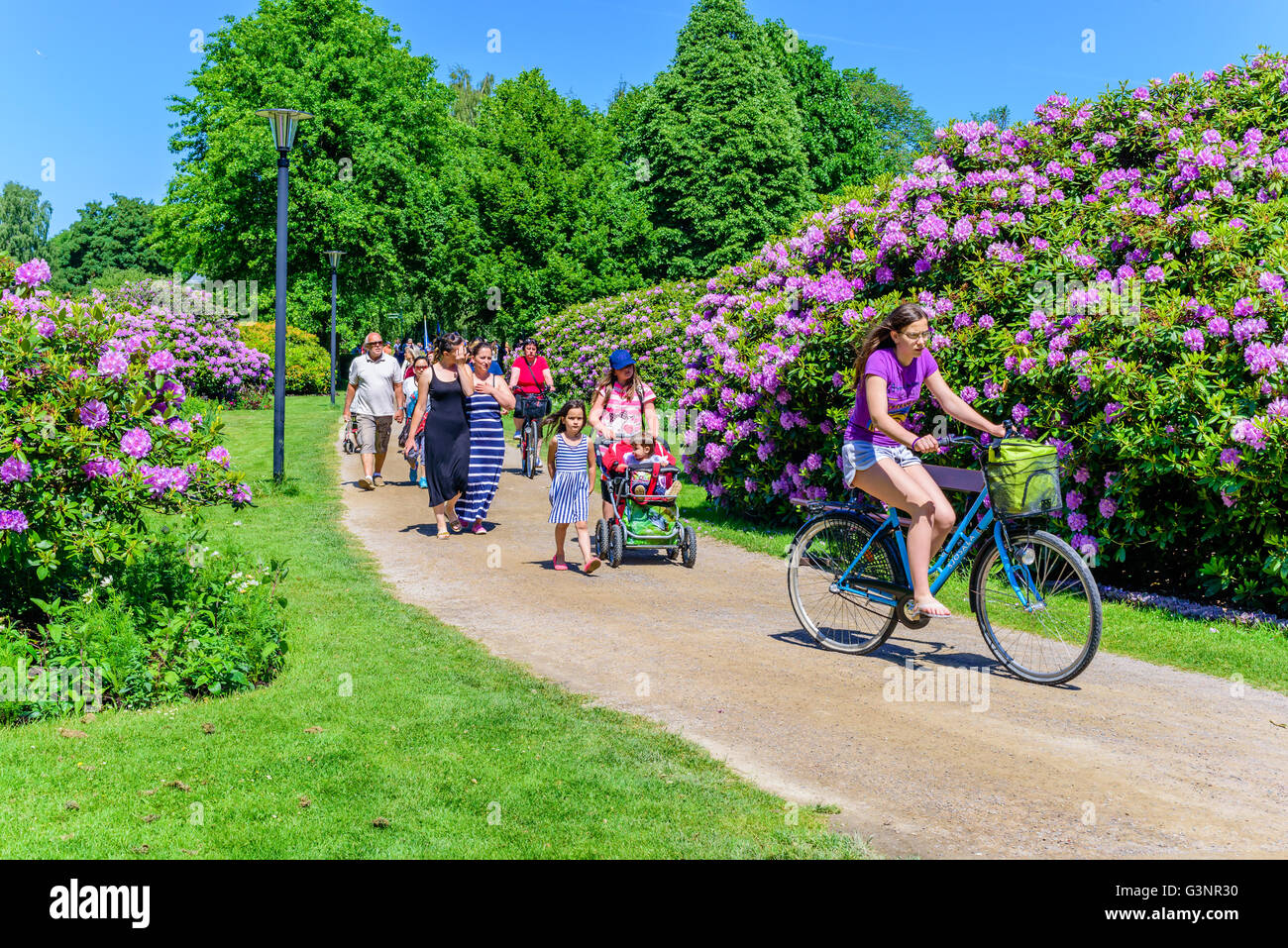 Ronneby, Suède - 6 juin 2016 : la fête nationale suédoise en parc public. Personnes à pied et à vélo sur un chemin de gravier Banque D'Images