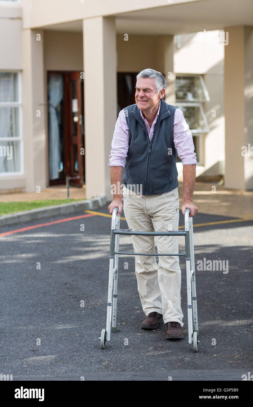 Hauts homme marchant avec un déambulateur Banque D'Images