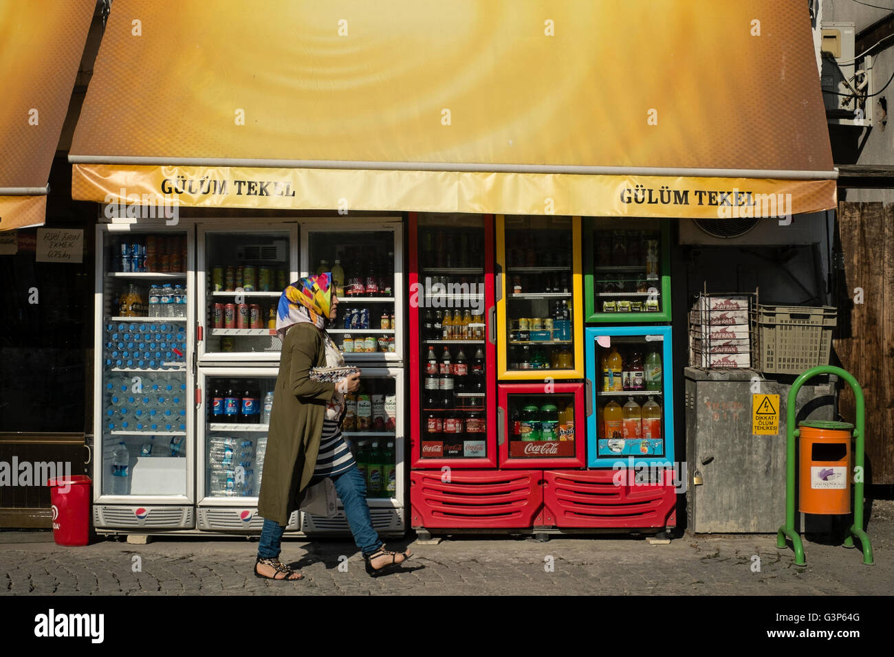 Une femme dans un foulard coloré passe devant un magasin à Safranbolu, Karabuk, Turquie Banque D'Images
