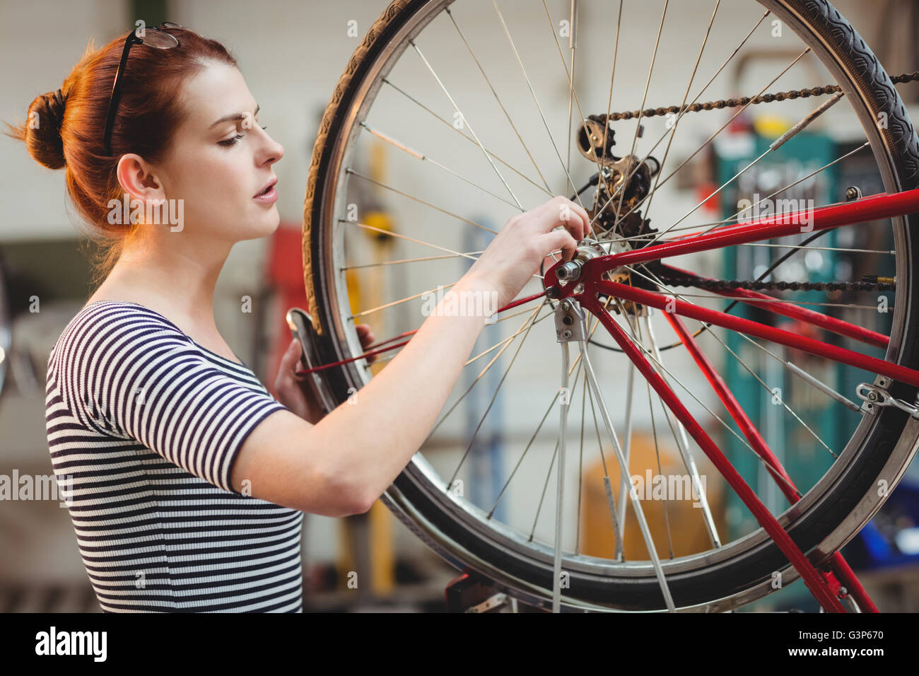 Femme de la réparation d'une roue de bicyclette Banque D'Images