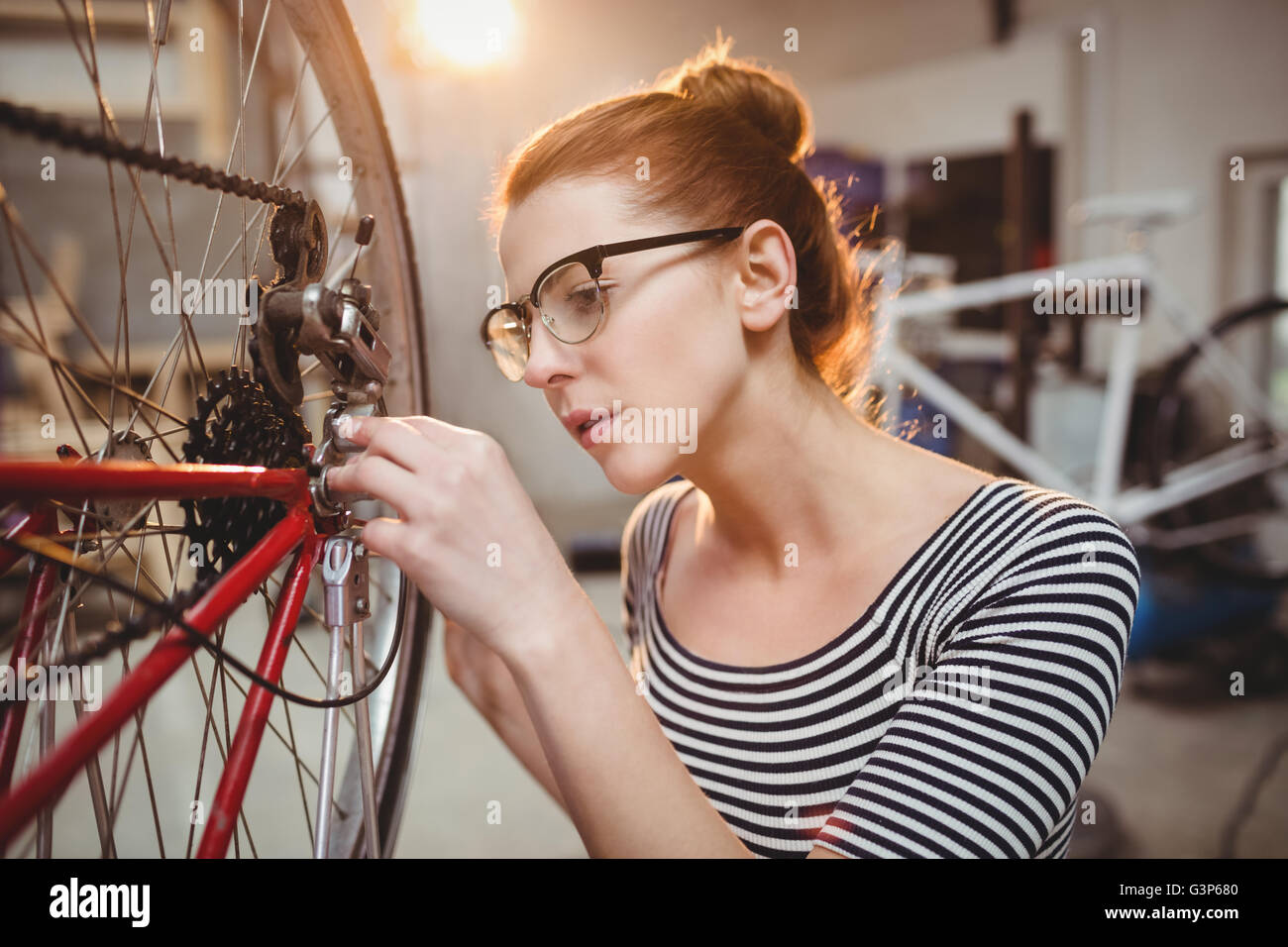 Femme de la réparation d'une roue de bicyclette Banque D'Images