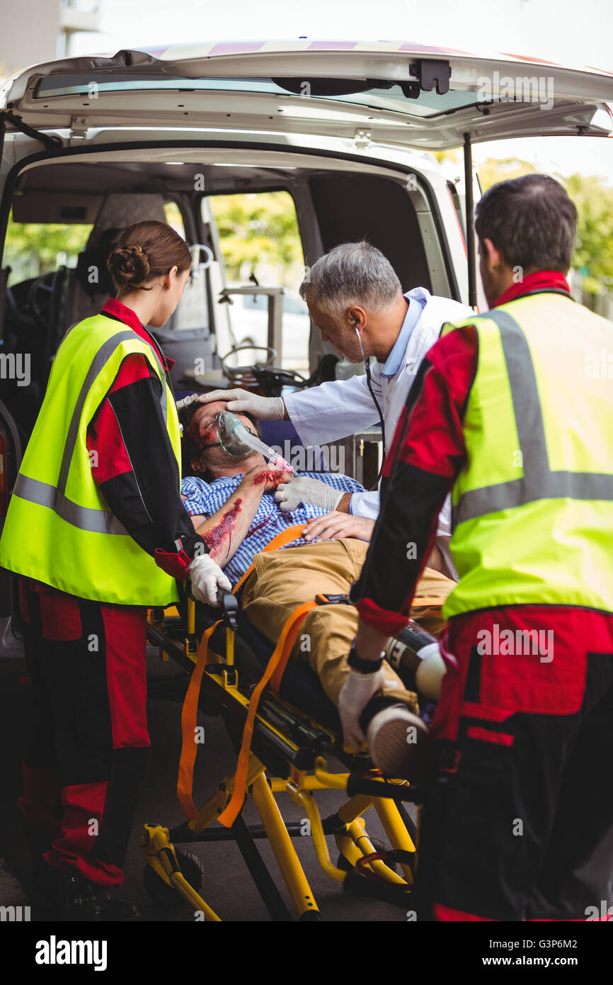 Équipe d'ambulanciers et un médecin en prenant soin d'un blessé Banque D'Images