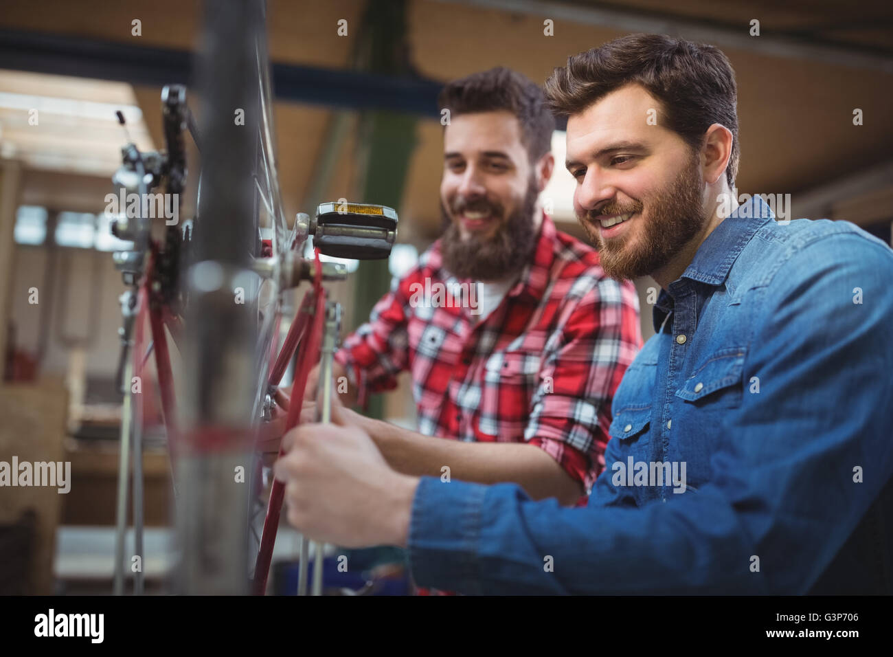 Vue latérale des deux mécaniciens réparant une location Banque D'Images