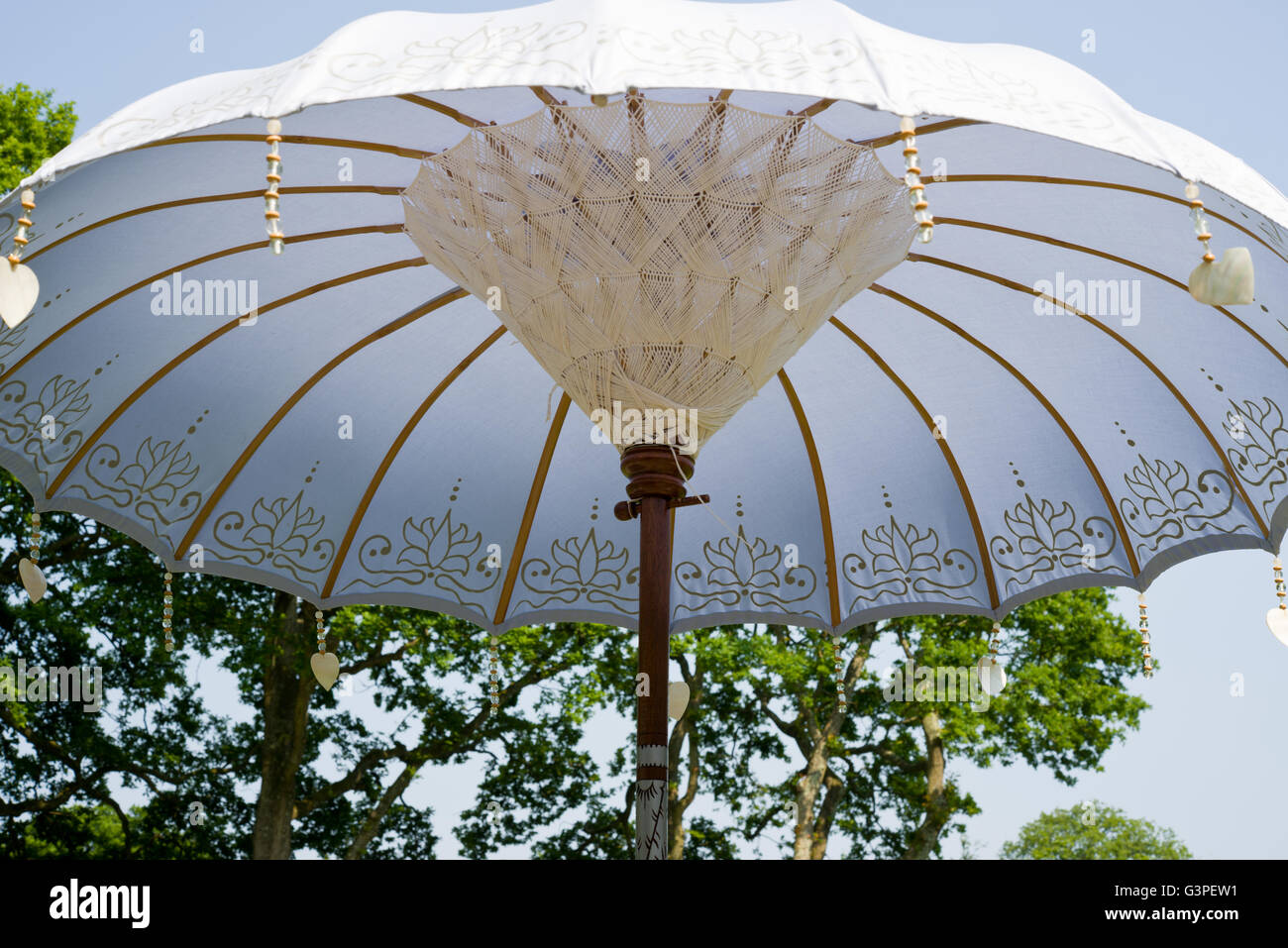 Parasol de jardin ou à l'ombre. Effets décoratifs de l'Extrême-Orient et shell coeurs pendentifs suspendus. Banque D'Images