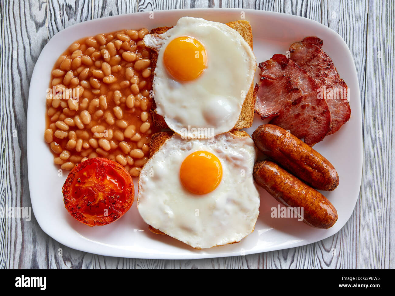 Petit déjeuner anglais avec deux œufs et bacon haricots saucisses tomates grillées Banque D'Images