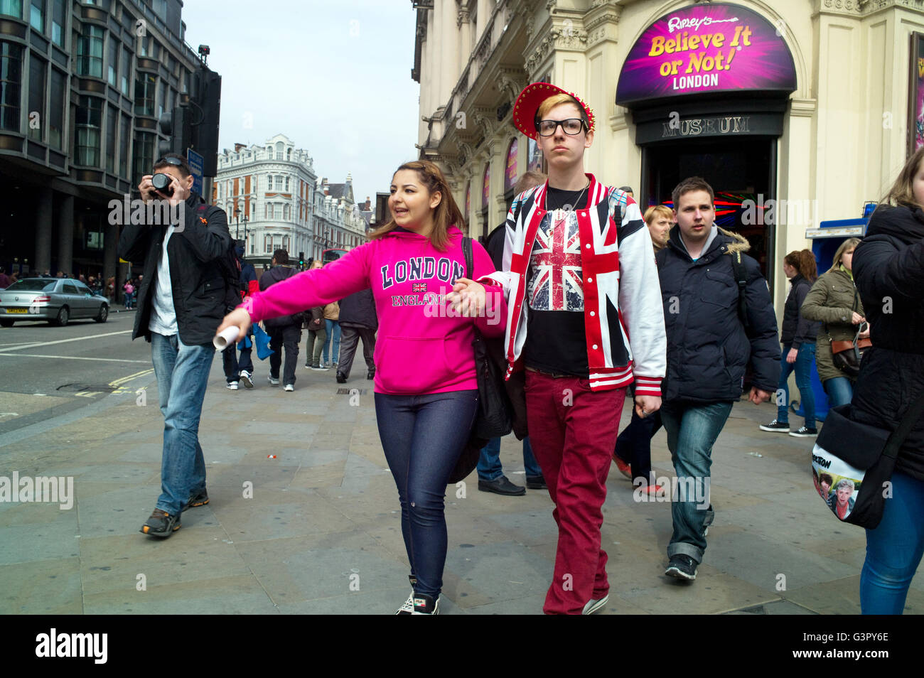 Deux jeunes touristes à Piccadilly Circus portent un tee-shirt et une veste Union Jack. Banque D'Images