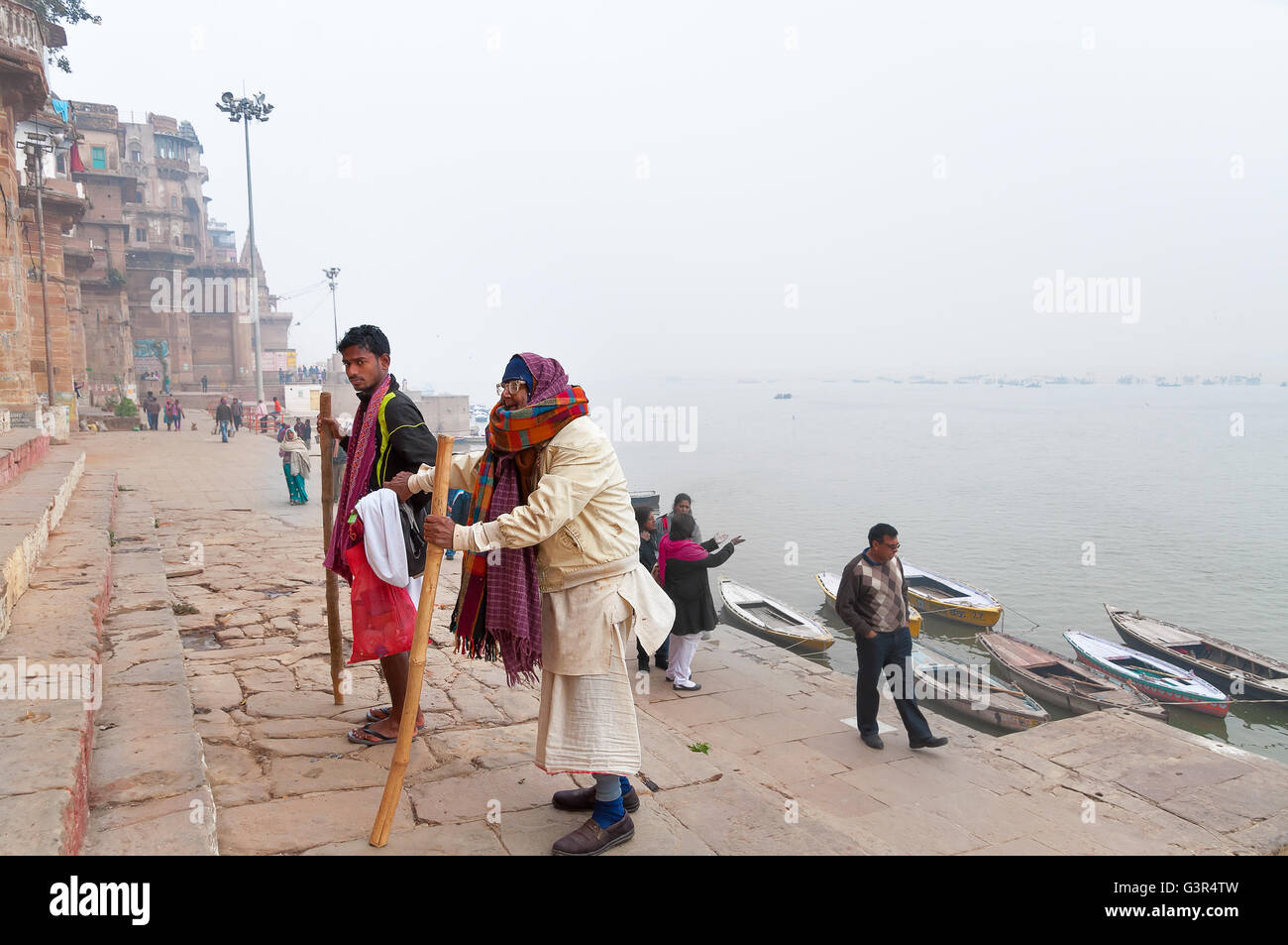 Vieil homme indien non identifié avec son fils, rendez-vous sur les mesures de Ghats de Varanasi. L'Uttar Pradesh, Inde Banque D'Images