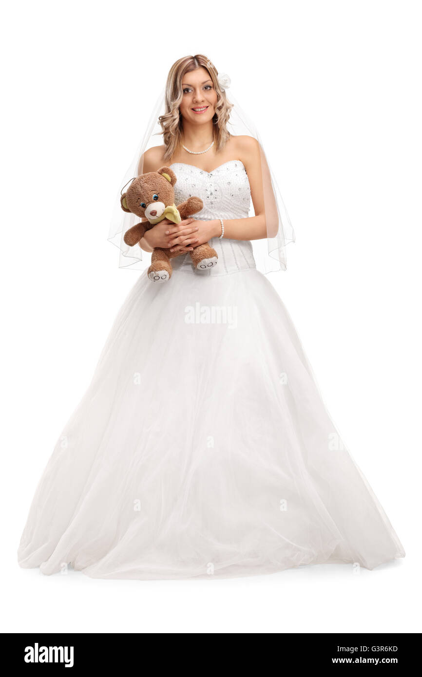 Portrait d'une jeune mariée dans une robe de mariée blanche holding a teddy bear isolé sur fond blanc Banque D'Images