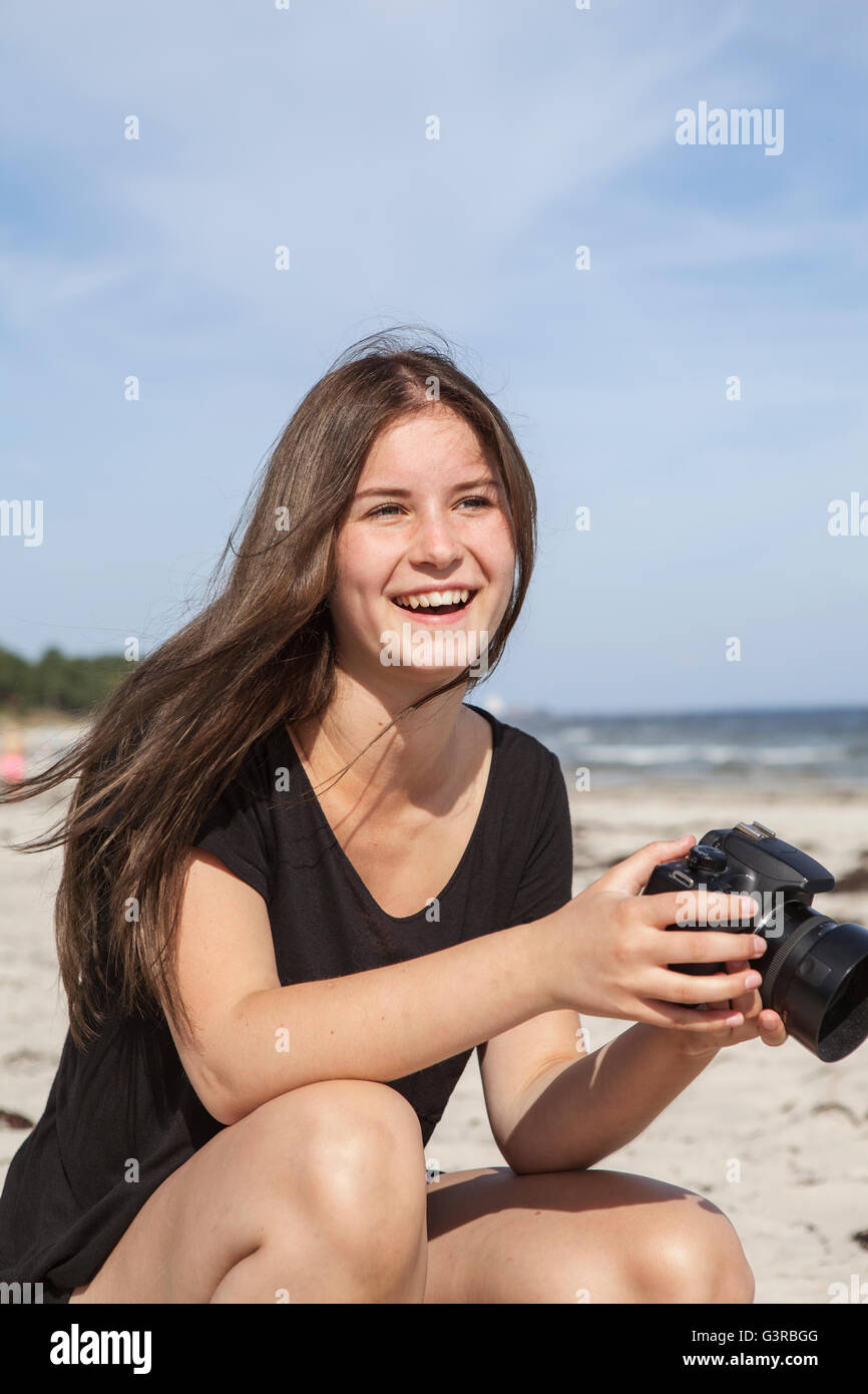 La Suède, Stockholm, l'Ahus, Teenage girl (16-17) prendre des photos sur la plage Banque D'Images