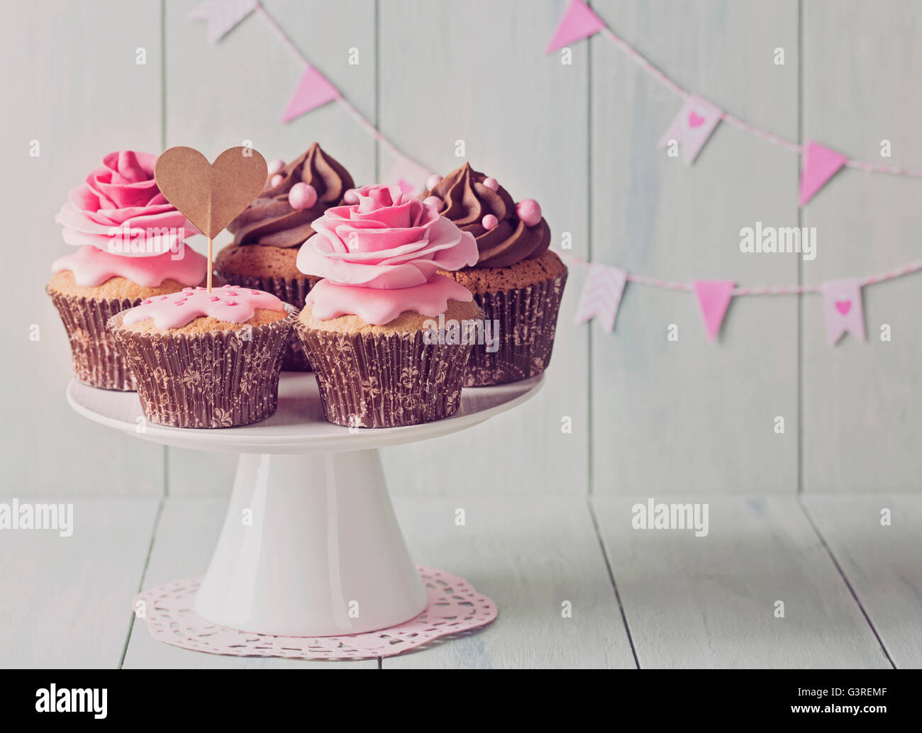 Cupcakes avec sweet rose des fleurs et une cakepick pour le texte Banque D'Images