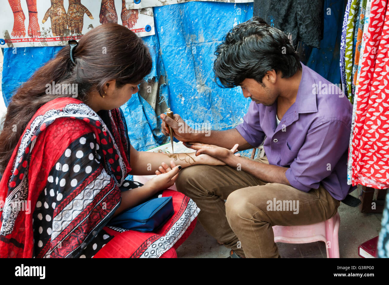 L'homme Indien non identifiés sur la pâte de henné peinture main de femme au marché Russell Russell Mar Banque D'Images
