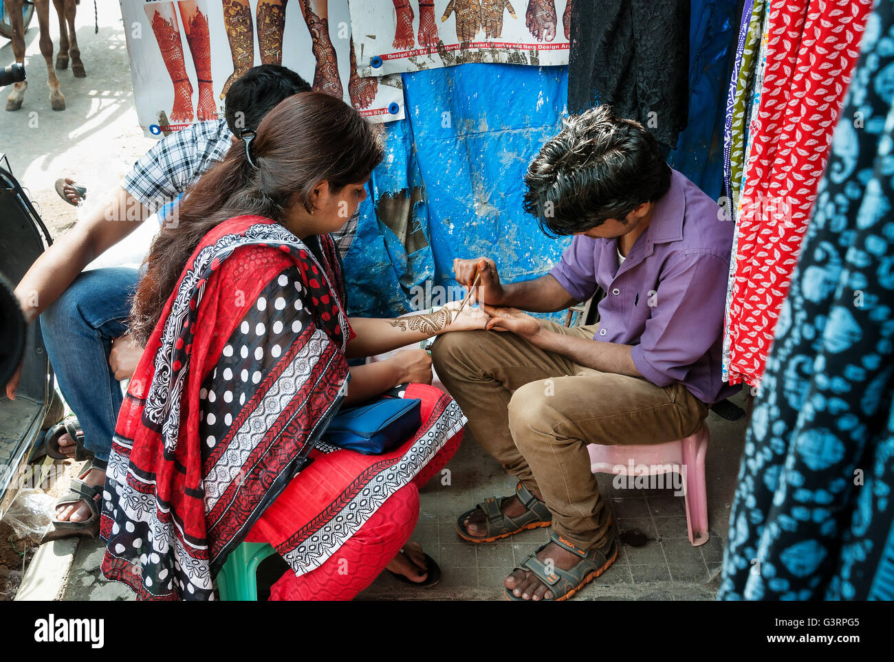 L'homme Indien non identifiés sur la pâte de henné peinture main de femme au marché Russell Russell Mar Banque D'Images