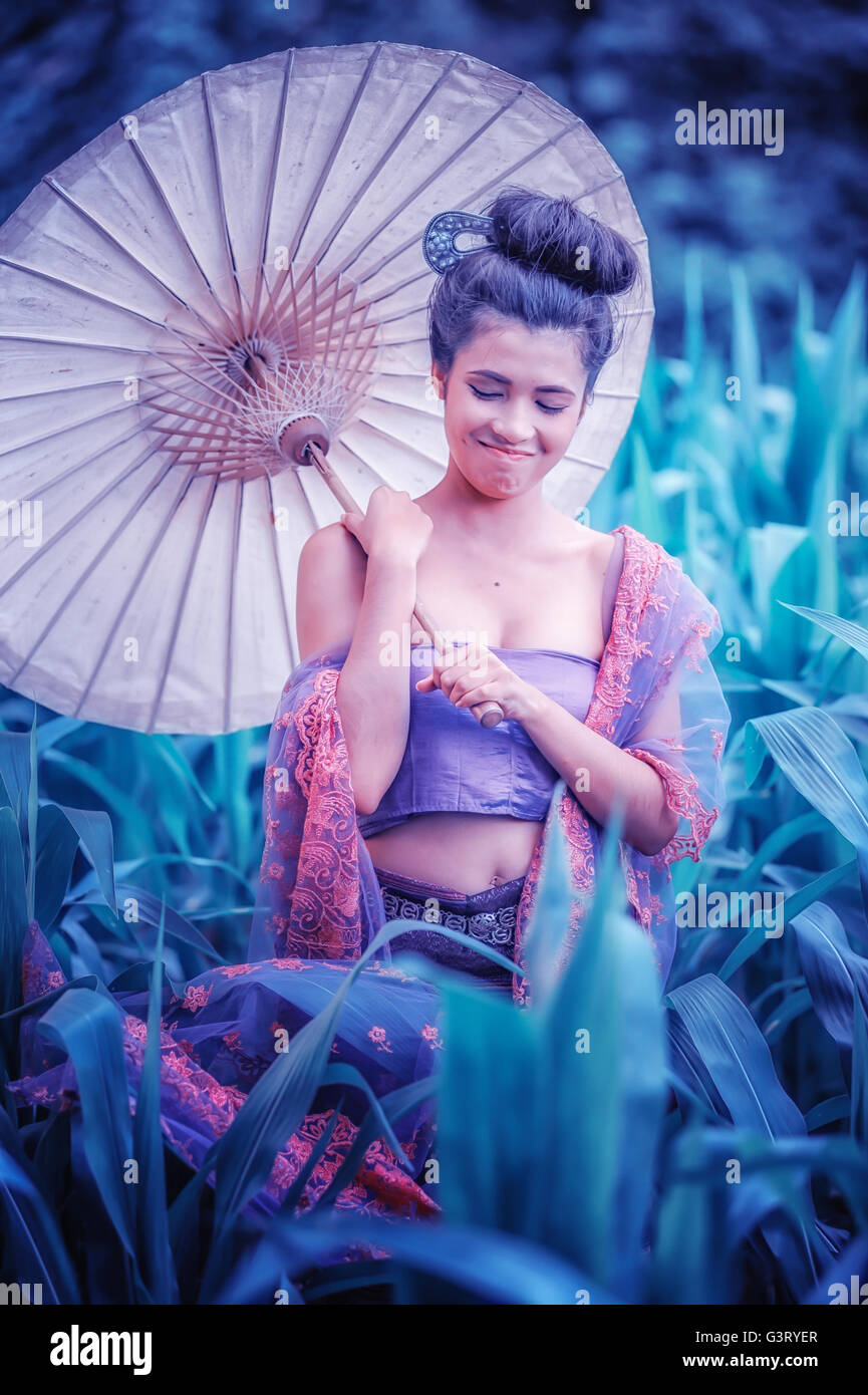 L'ancienne femme thaïlandaise en costume traditionnel de la Thaïlande avec parapluie vintage, effet vintage Banque D'Images