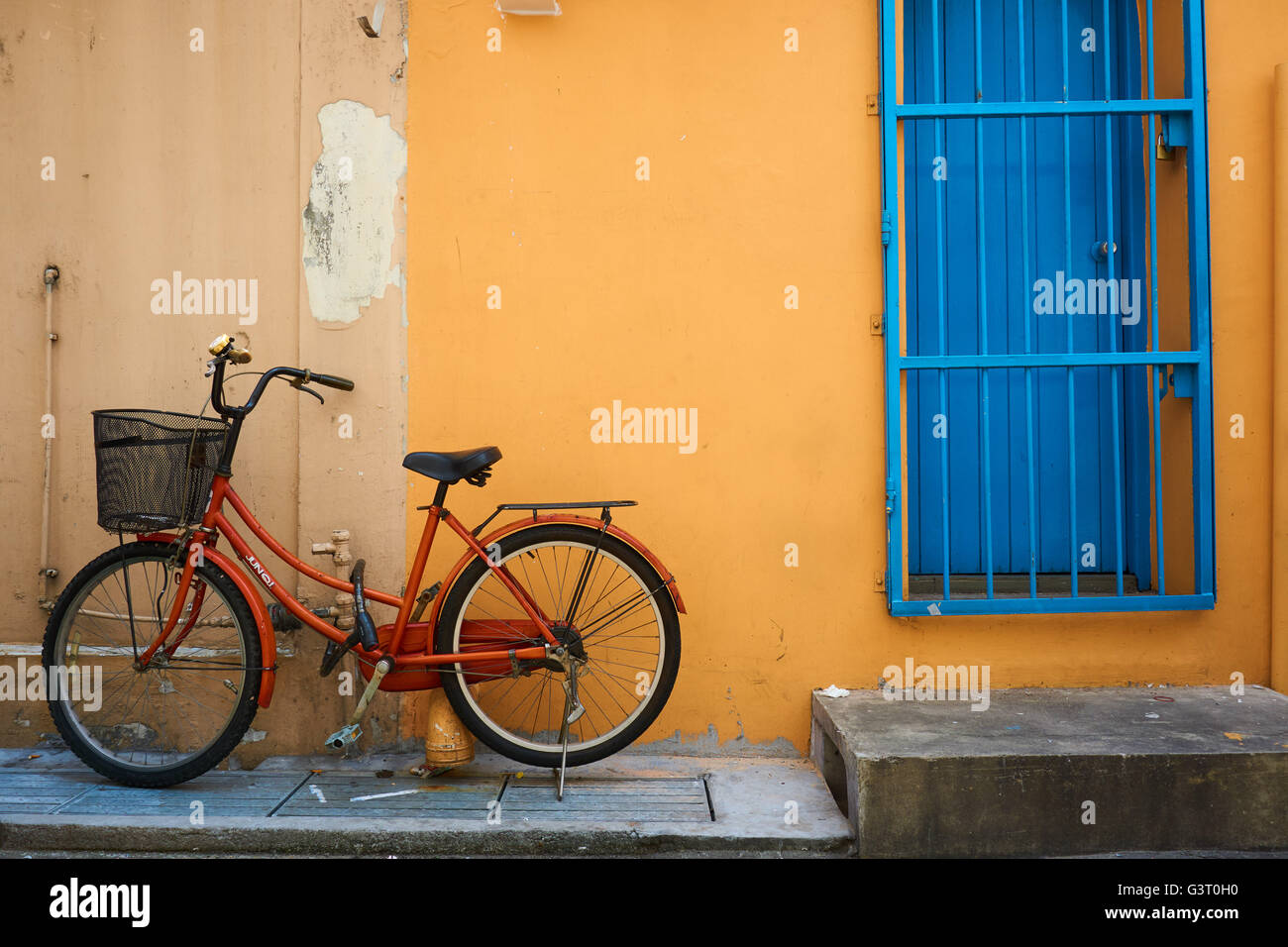 Vieux vélo contre le mur jaune Banque D'Images