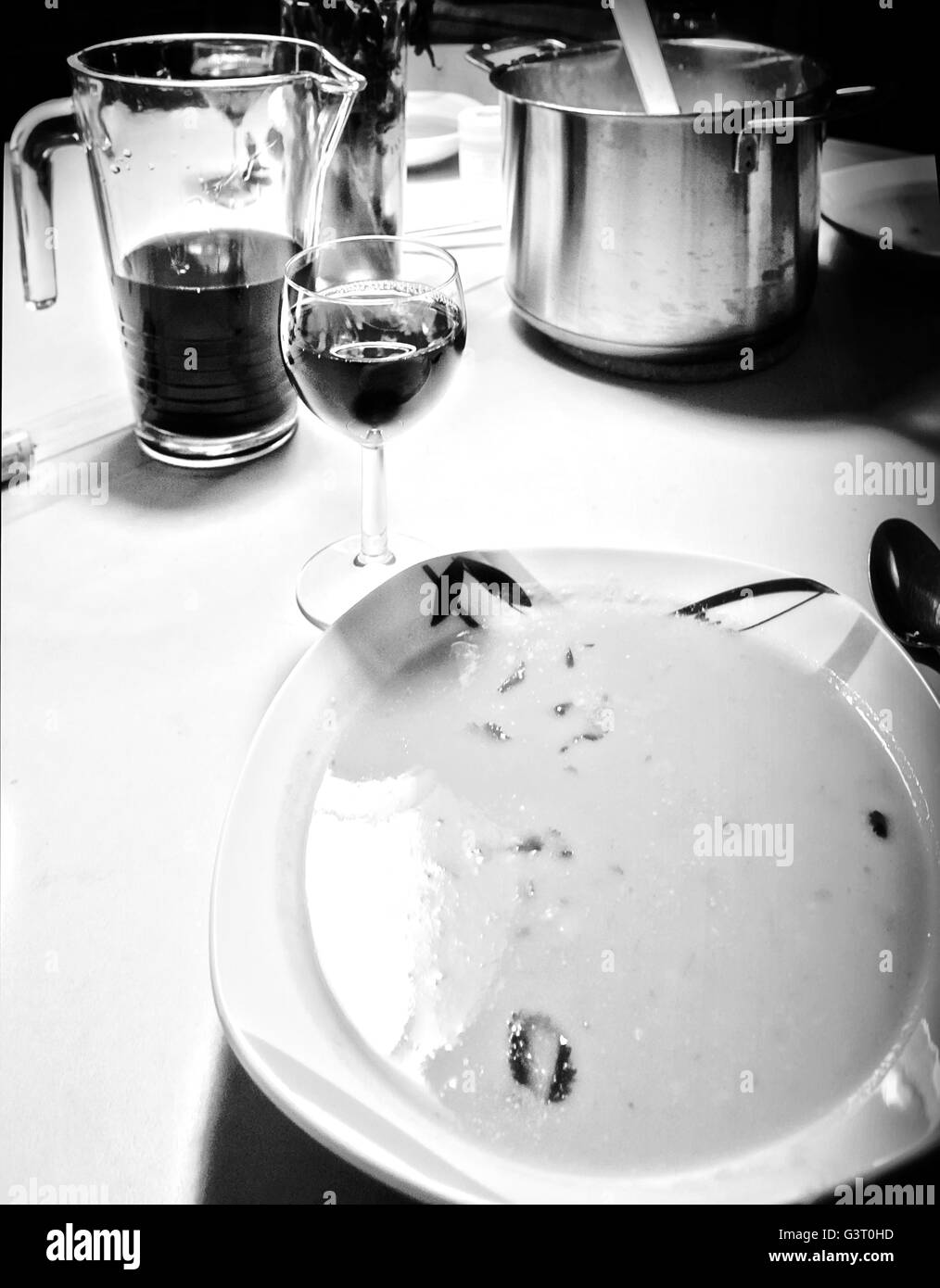 Soupe sur la table de cuisine accompagnée d'un verre de vin rouge, atmosphère agréable entre amis Banque D'Images