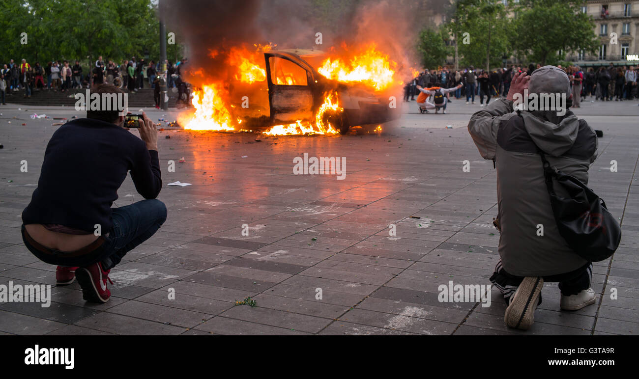 Paris, France. 14 Juin, 2016. Prendre des photos des manifestants d'un véhicule en feu sur la Place de la République à Paris, France, 14 juin 2016. Il est venu à des émeutes en marge de nouvelles manifestations contre la réforme du marché de l'emploi d'une controverse. Photo : Peter Kneffel/dpa/Alamy Live News Banque D'Images