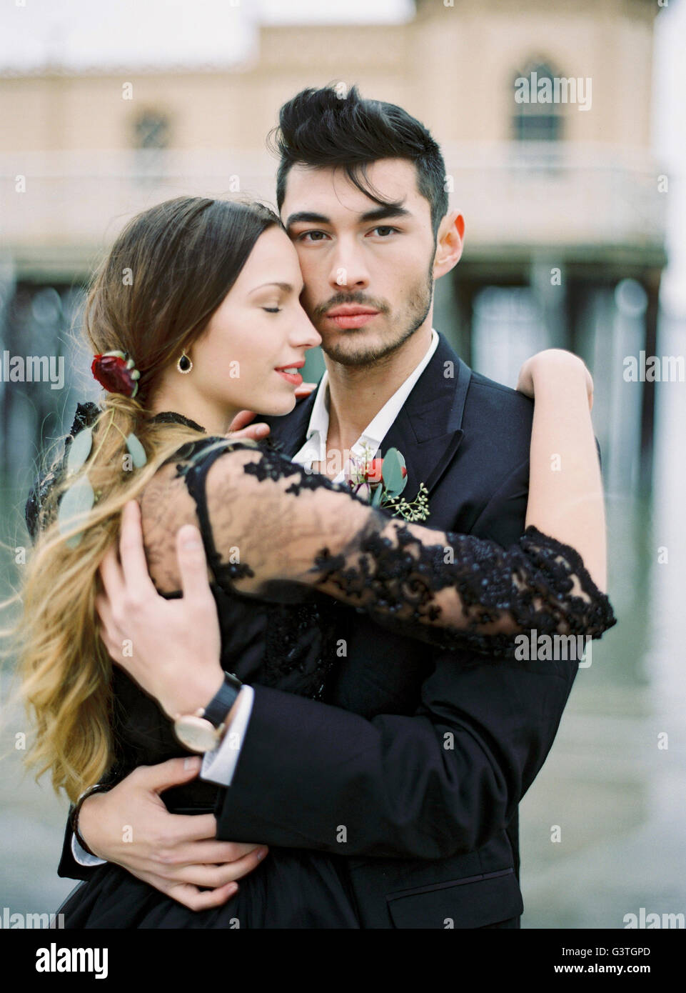 La Suède, Halland, Varberg, jeunes habillés formellement couple hugging Banque D'Images