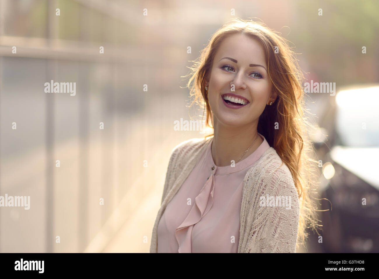 Jeune femme en riant vers la caméra au début de la lumière du soleil du matin en plein air avec copie espace tho la gauche Banque D'Images