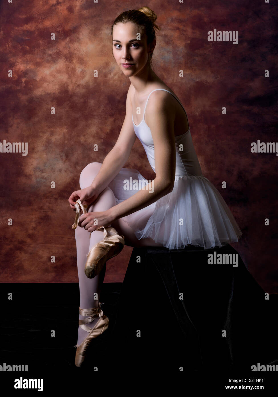 Portrait d'une ballerine en mettant son pointes Banque D'Images