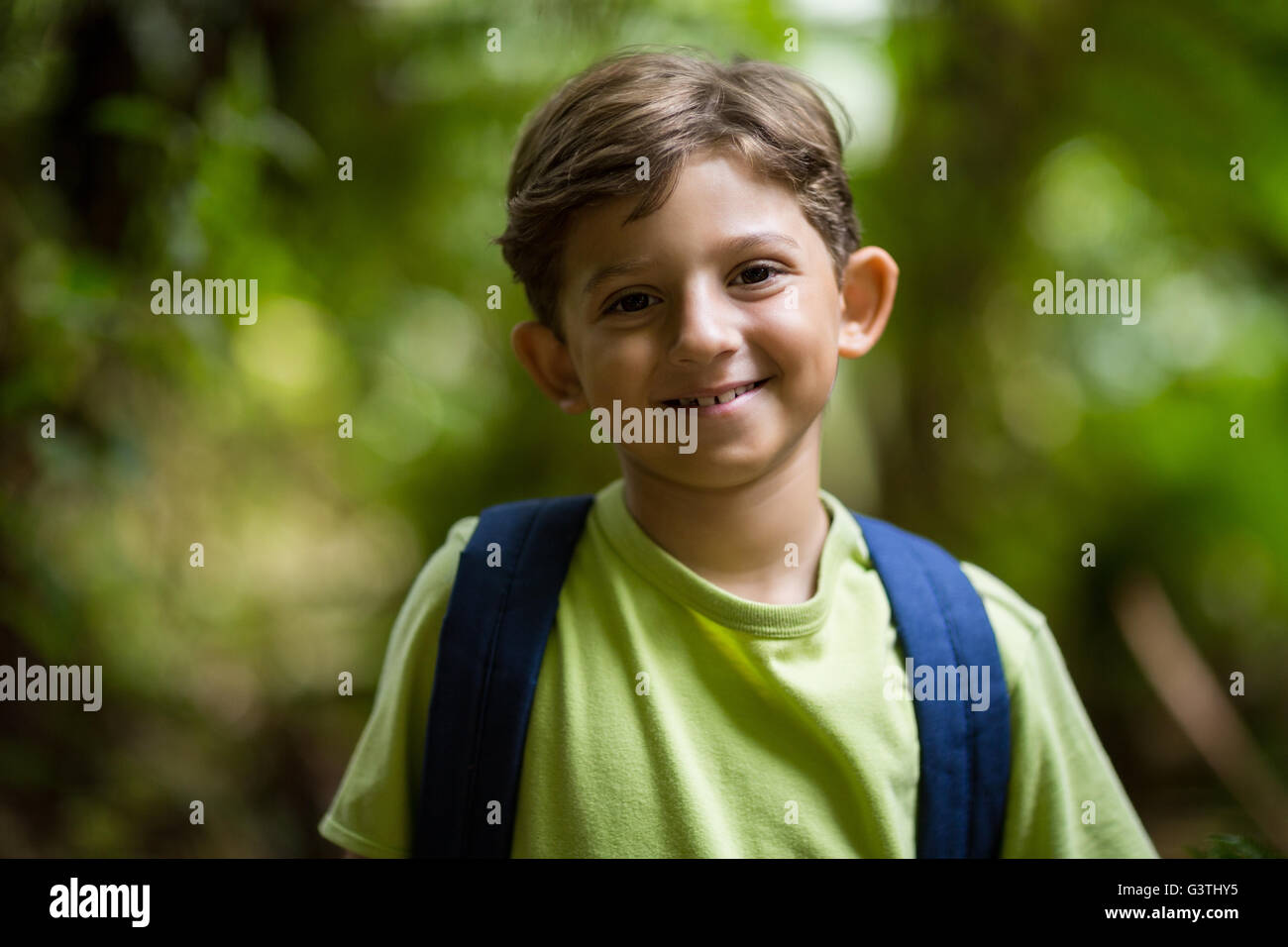 Smiling boy standing in a forest Banque D'Images
