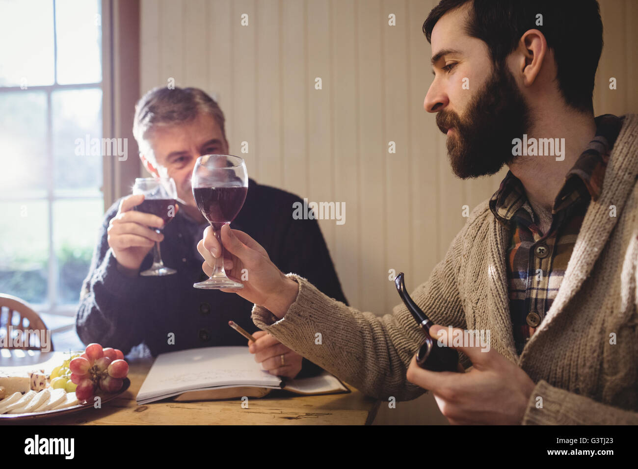 Hipster et homme mûr examen de vin rouge Banque D'Images