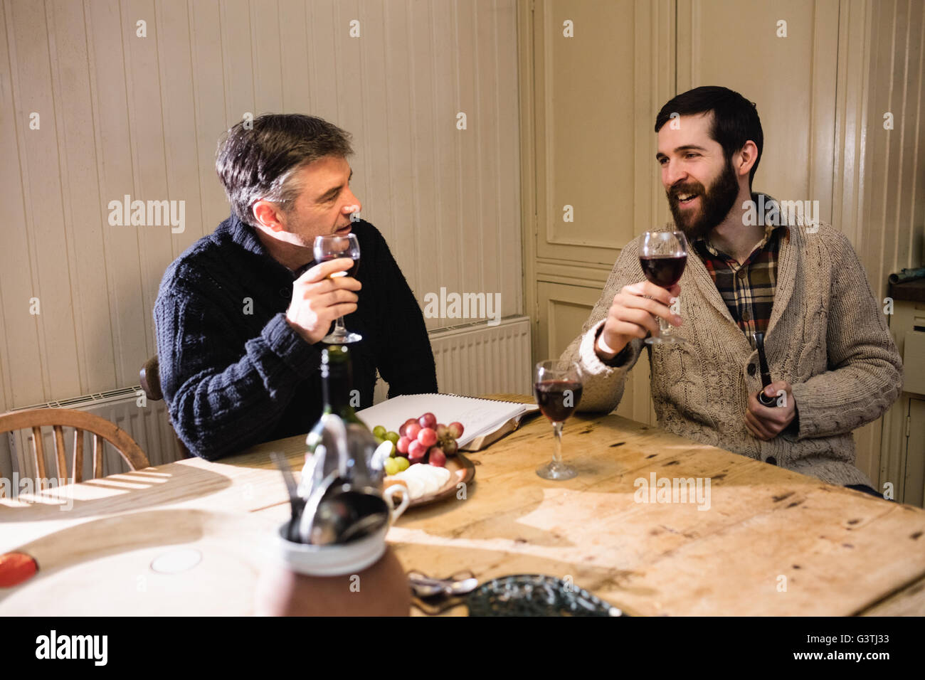 Hipster et homme mûr ayant une discussion tout en buvant du vin rouge Banque D'Images