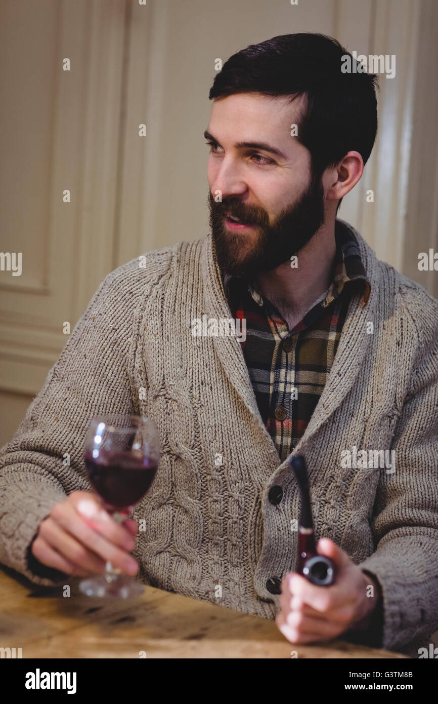 Hipster attrayant drinking Red Wine et pipe Banque D'Images