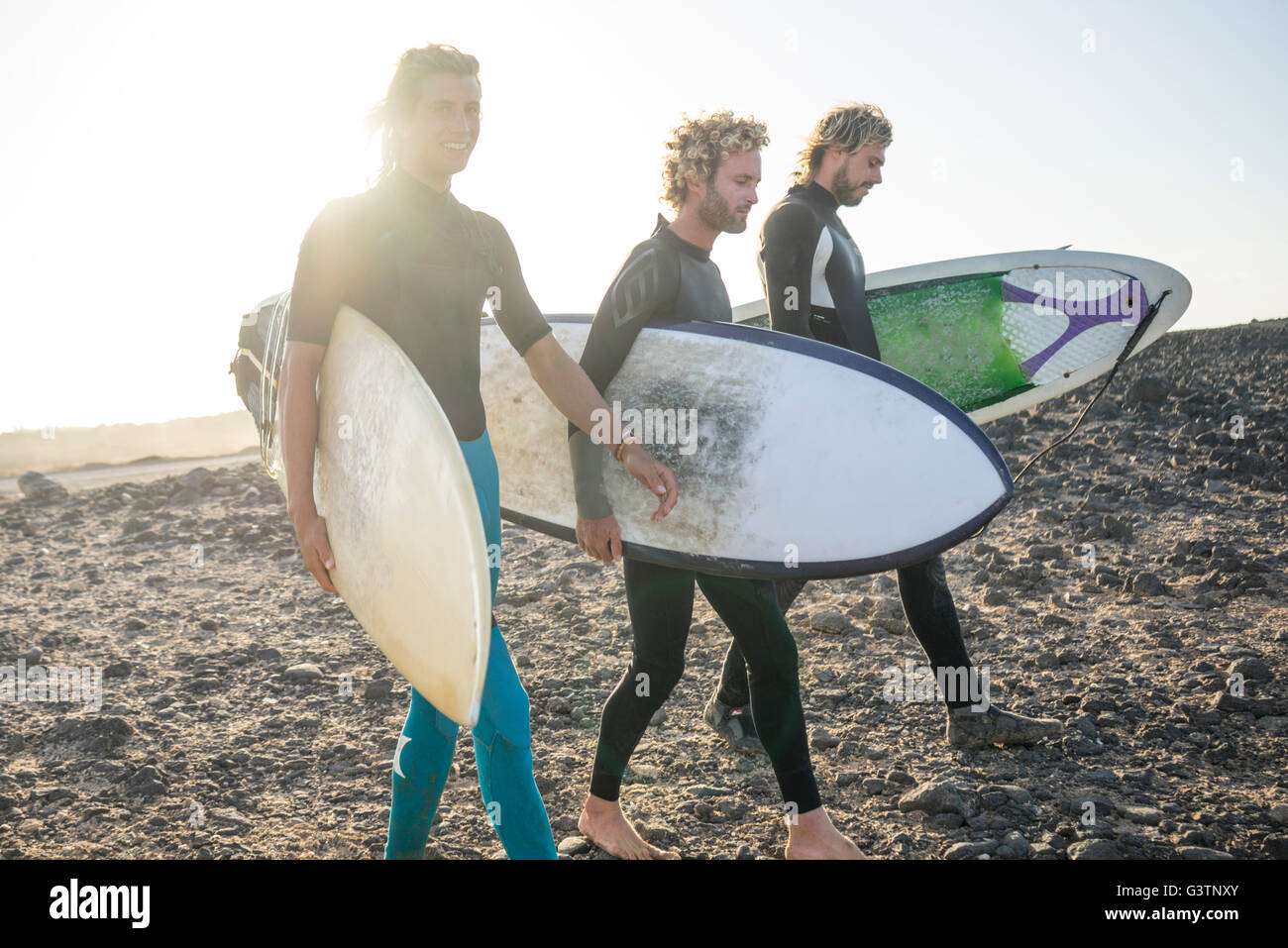 Trois hommes se préparent à surfer à Corralejo, Fuerteventura. Banque D'Images