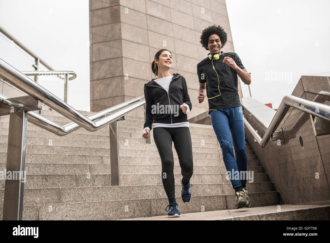 Un jeune couple de souplesse avant un jogging le long de la rive sud de Londres. Banque D'Images