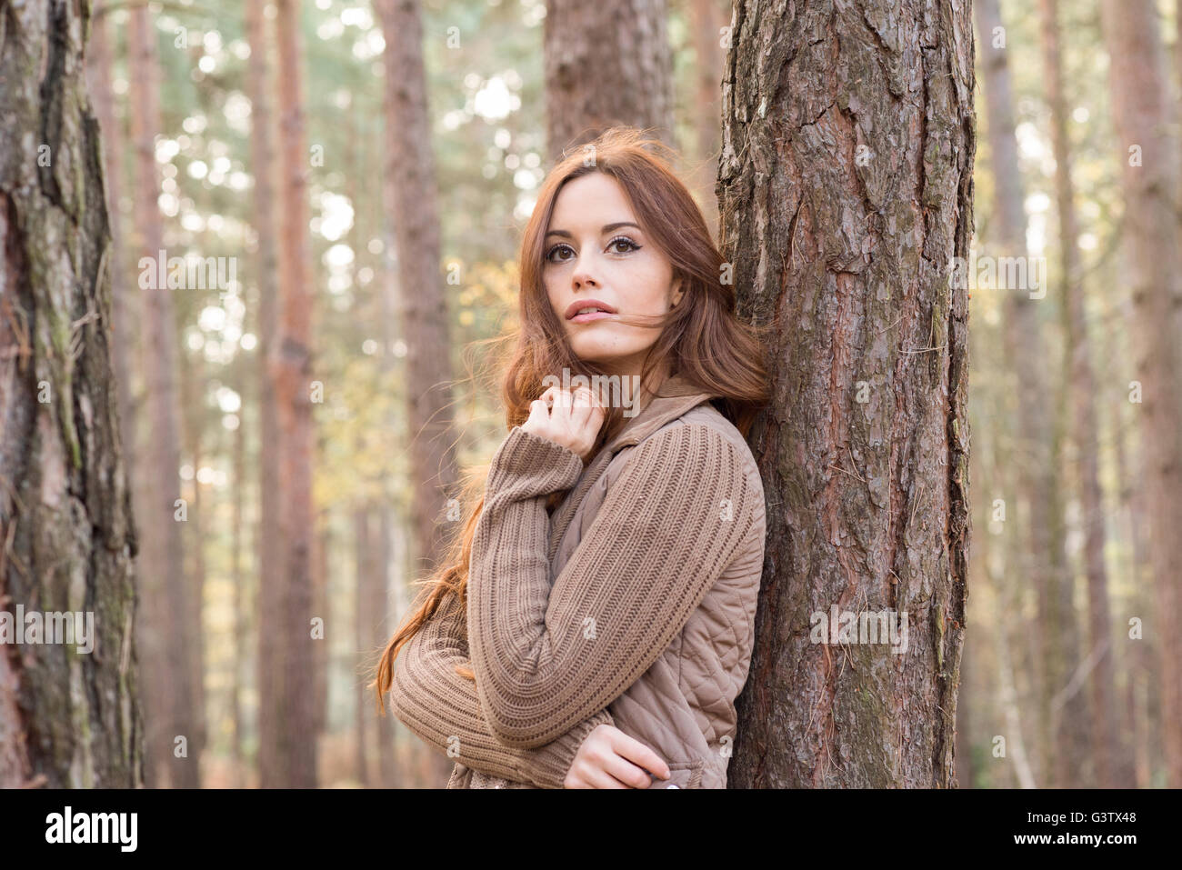 Une jeune femme communiant avec la nature dans une forêt en automne. Banque D'Images