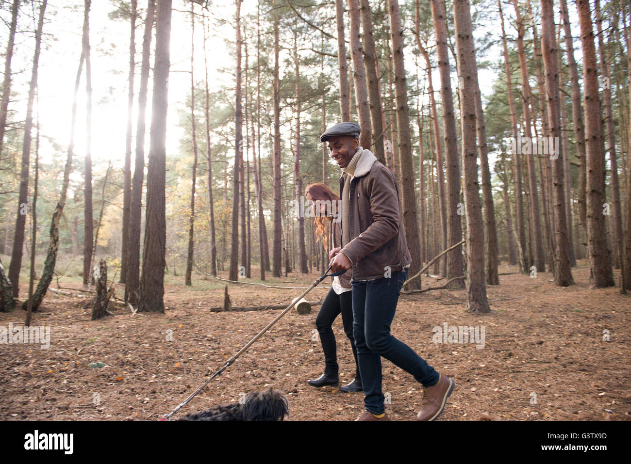 Un jeune couple avec leur chien sur une forêt Promenade en automne. Banque D'Images