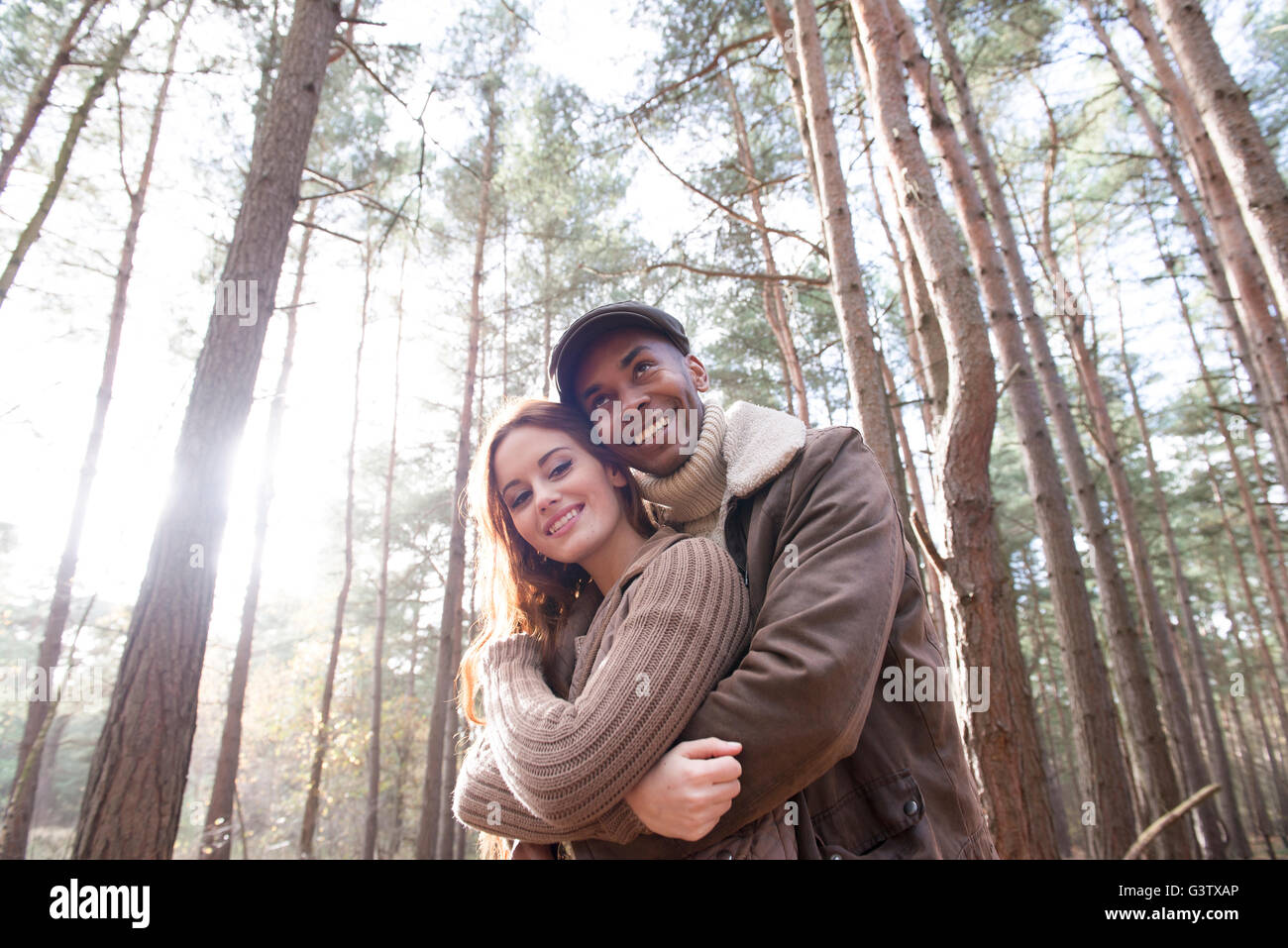 Un jeune couple cuddling sur une forêt Promenade en automne. Banque D'Images
