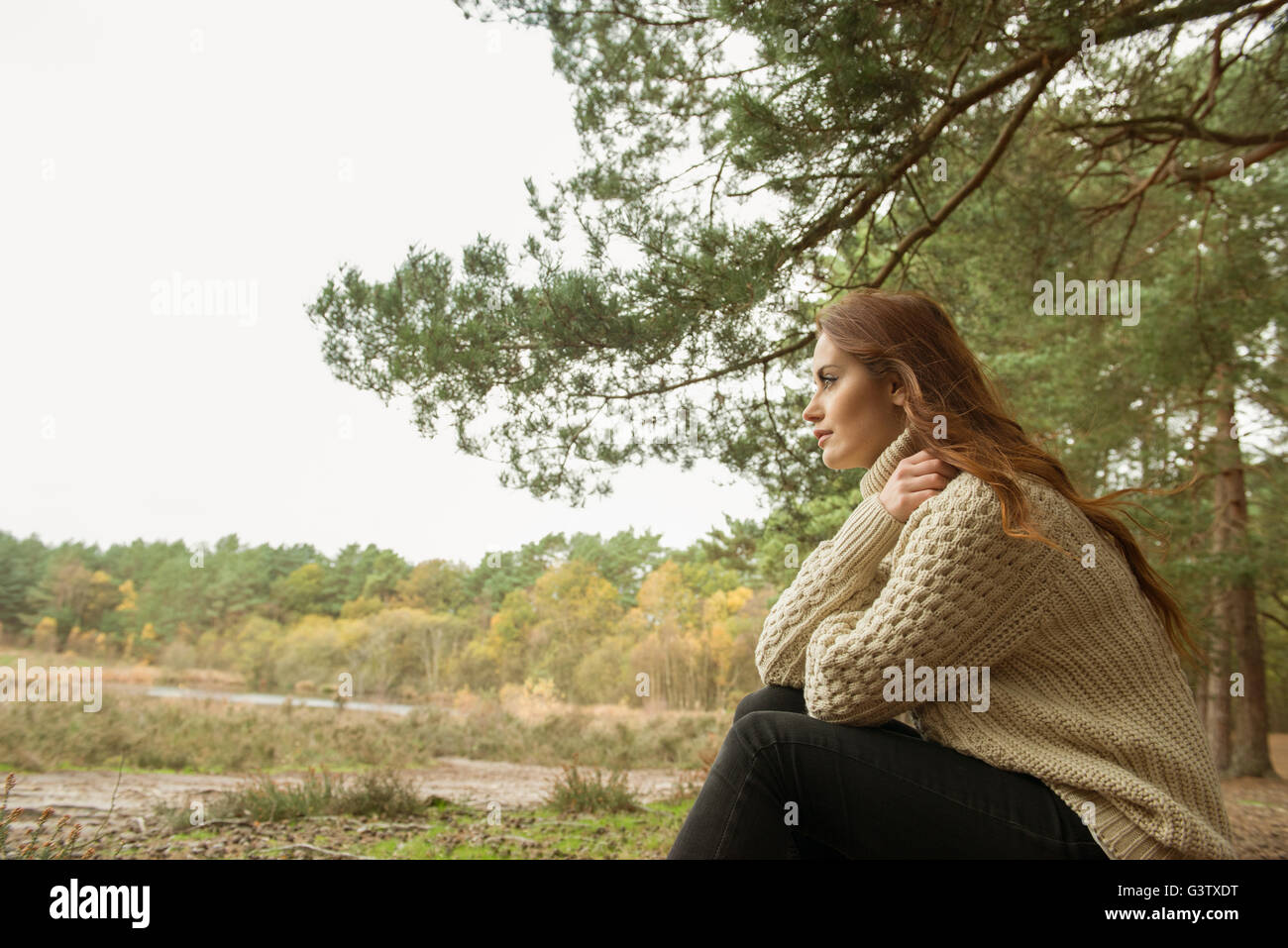 Une jeune femme communiant avec la nature sur une forêt Promenade en automne. Banque D'Images