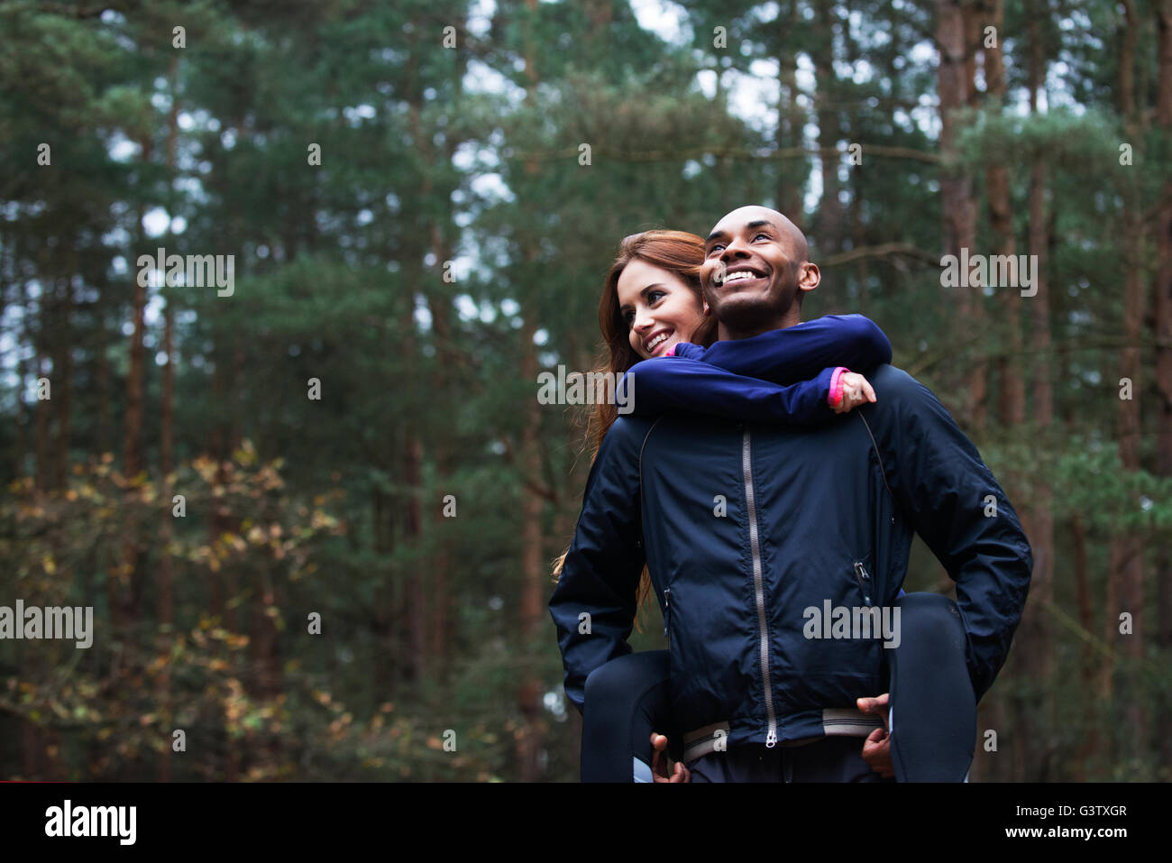 Un jeune couple appréciant l'environnement forestier après une course à travers la forêt en automne. Banque D'Images