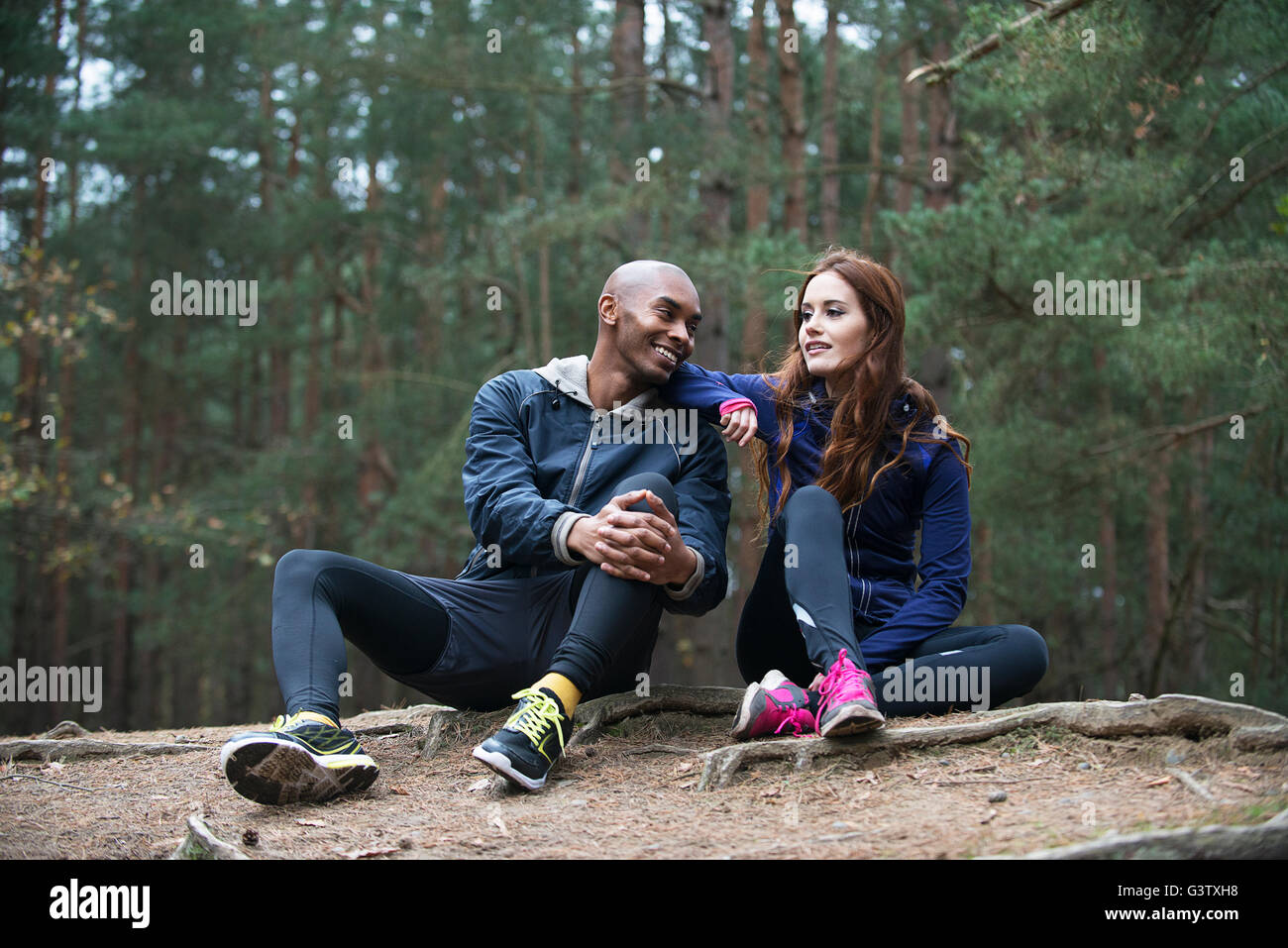 Un jeune couple d'être ensemble après une course à travers la forêt en automne. Banque D'Images