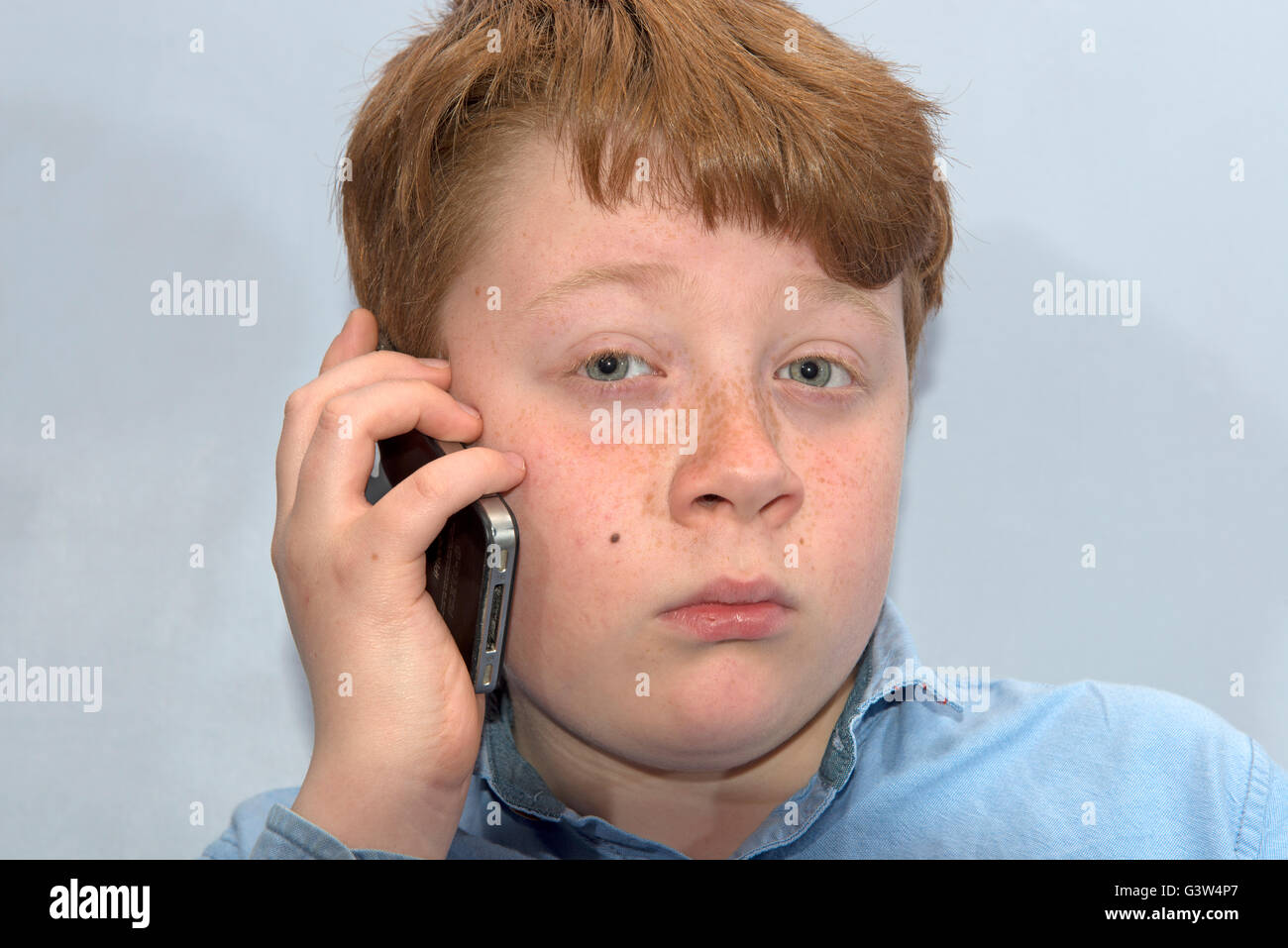 Un garçon de 10 ans avec un téléphone mobile Banque D'Images