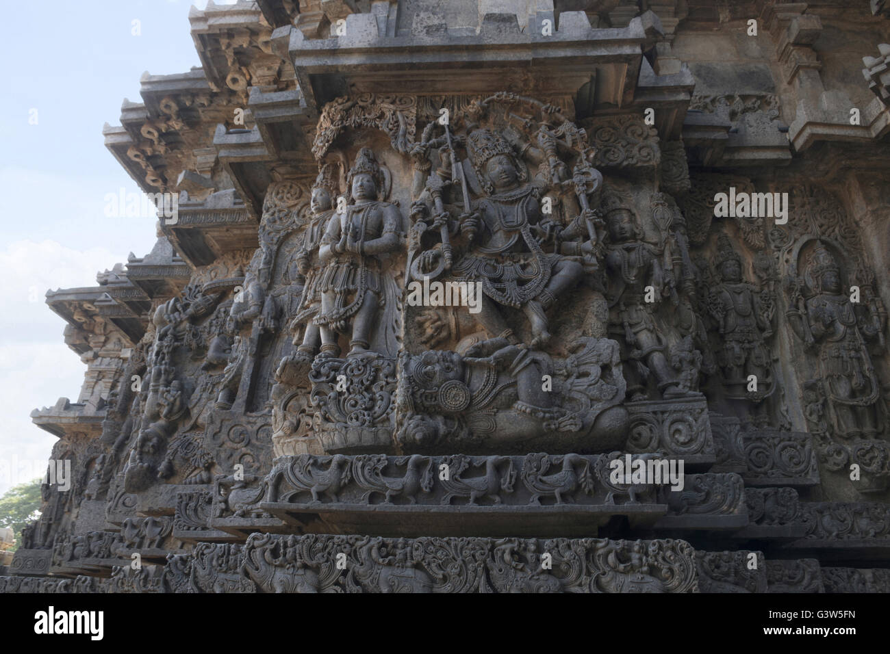 Mur décoré de bord bas-reliefs représentant shiva et d'autres déités, côté ouest, temple hoysaleshwara, halebidu, Karnataka, Inde. Banque D'Images