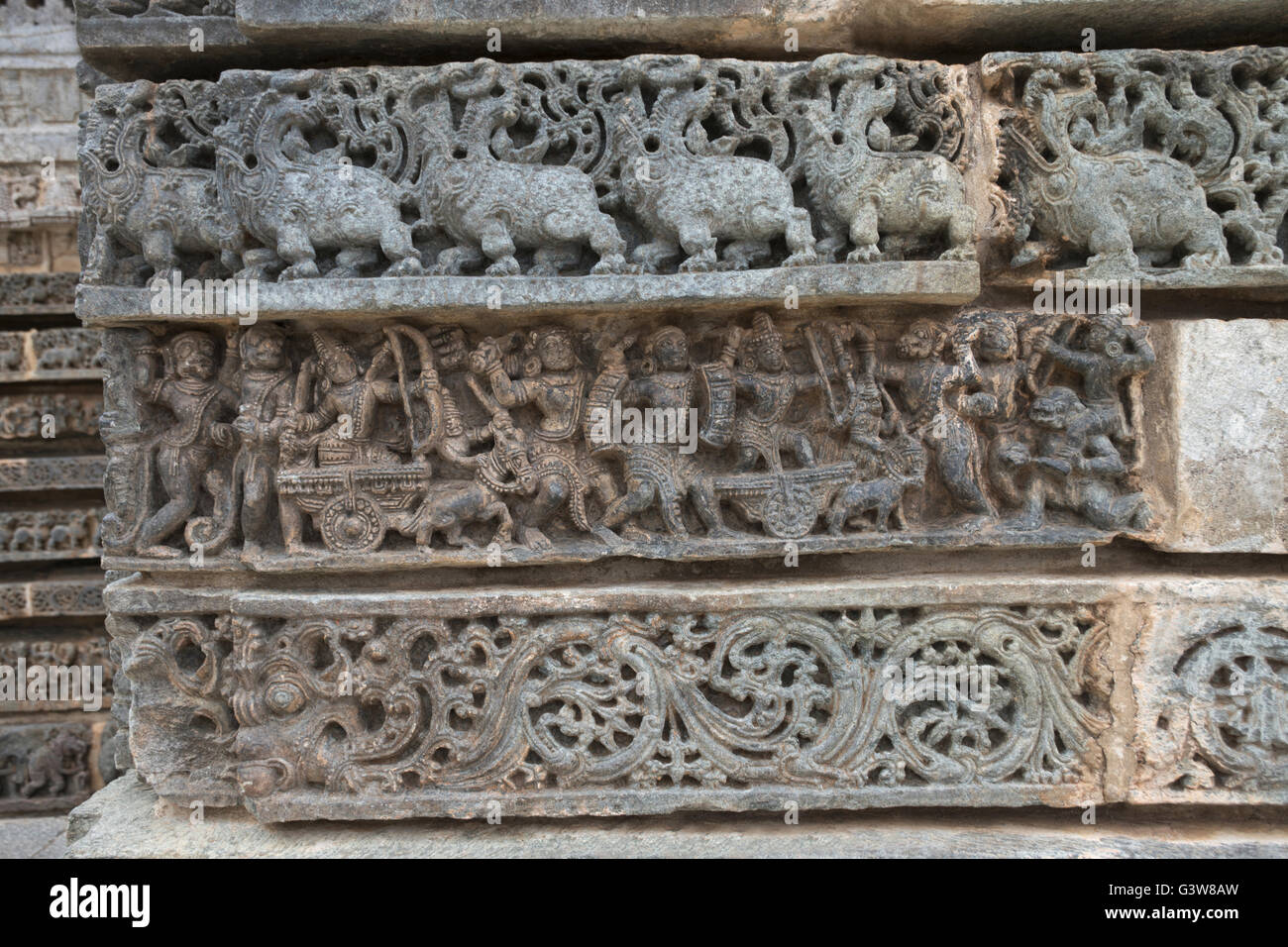 Les frises à la base du temple. kedareshwara temple, halebidu, Karnataka, Inde. (À partir du haut - makara, épisode de la guerre de ramayana) Banque D'Images